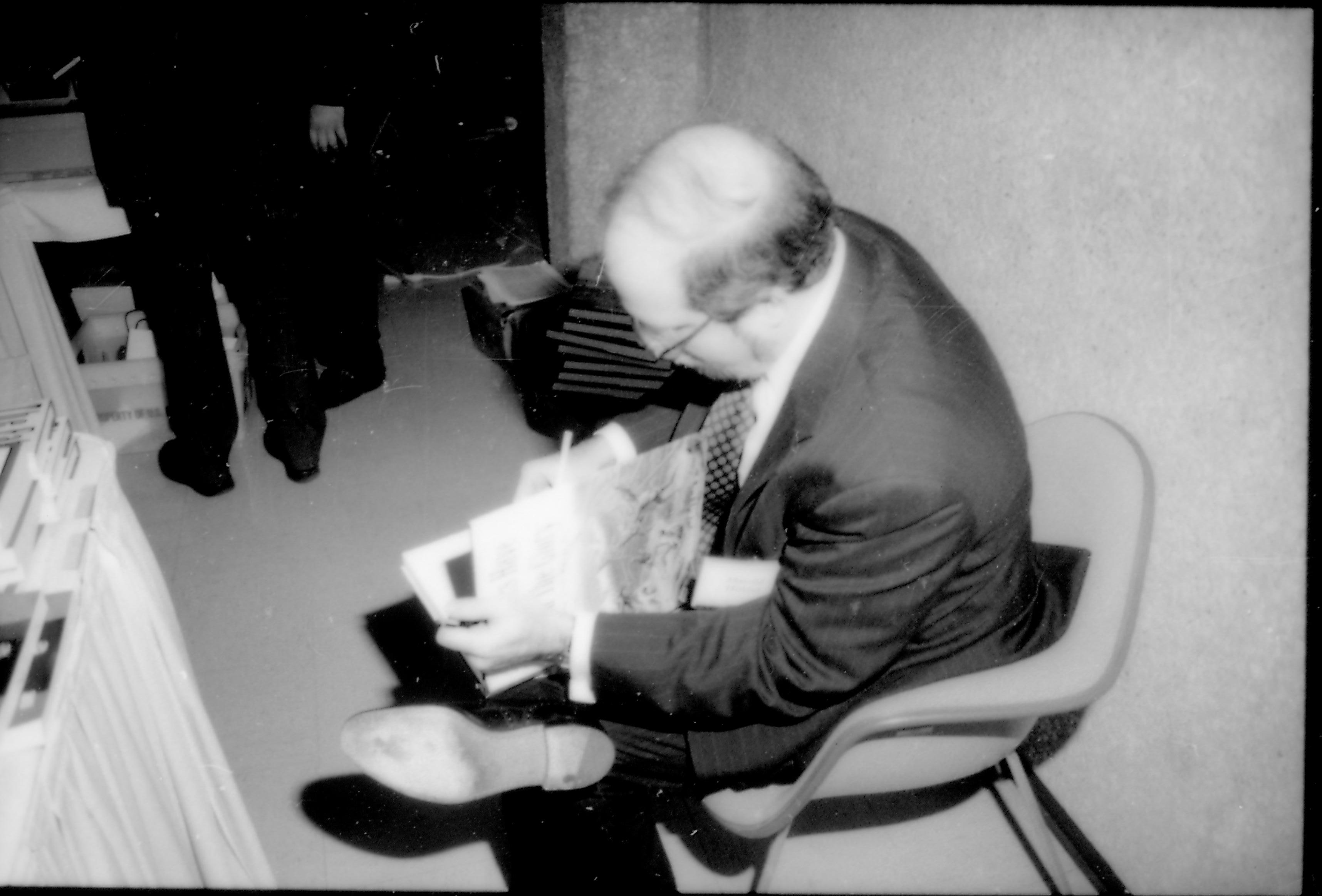 Man seated singing book. 8th Annual Lincoln Colloquium; E Lincoln, Colloquium