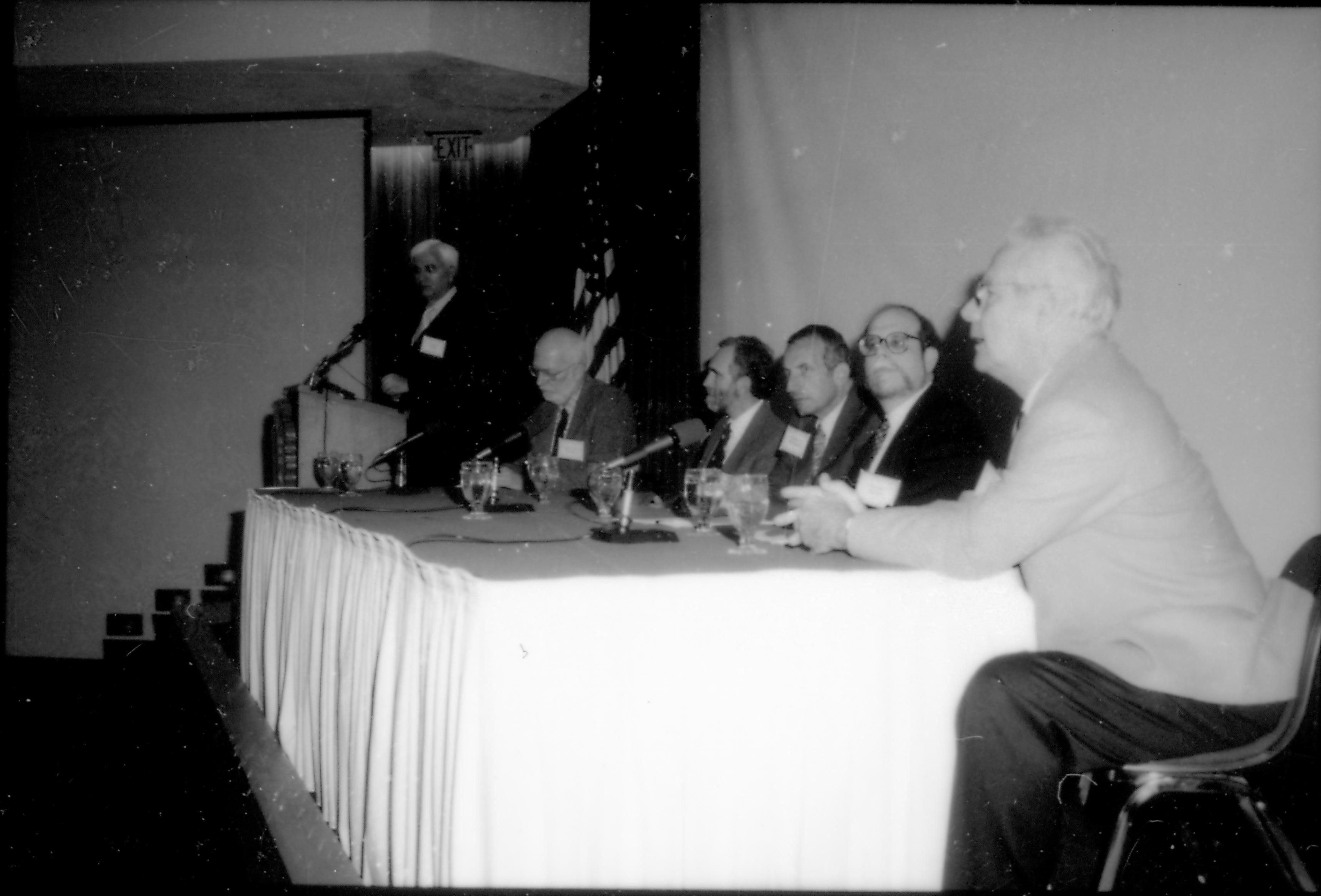 Speakers sitting at table, one at podium. 8th Annual Lincoln Colloquium; E Lincoln, Colloquium