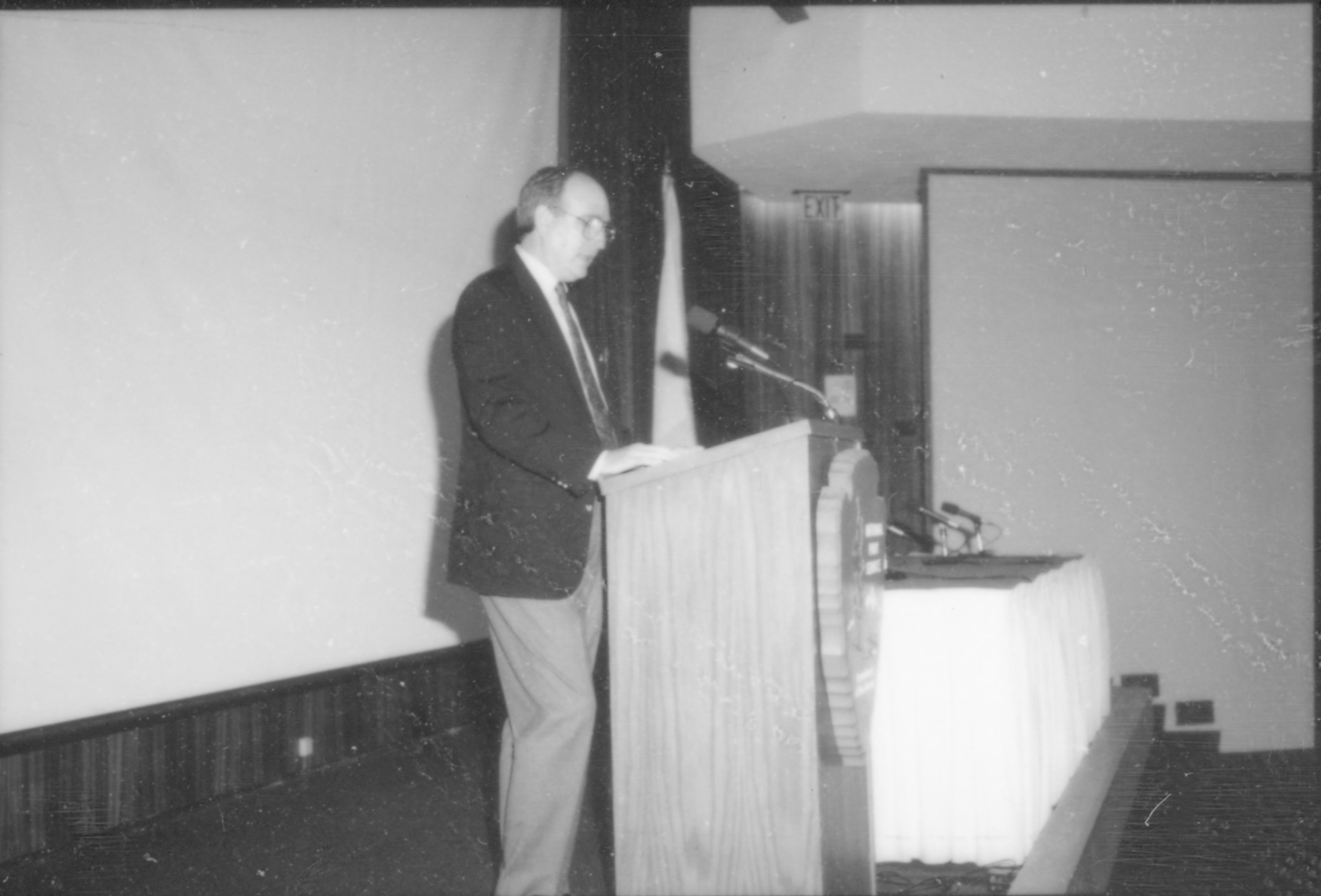 Man speaking at podium. 8th Annual Lincoln Colloquium; D Lincoln, Colloquium