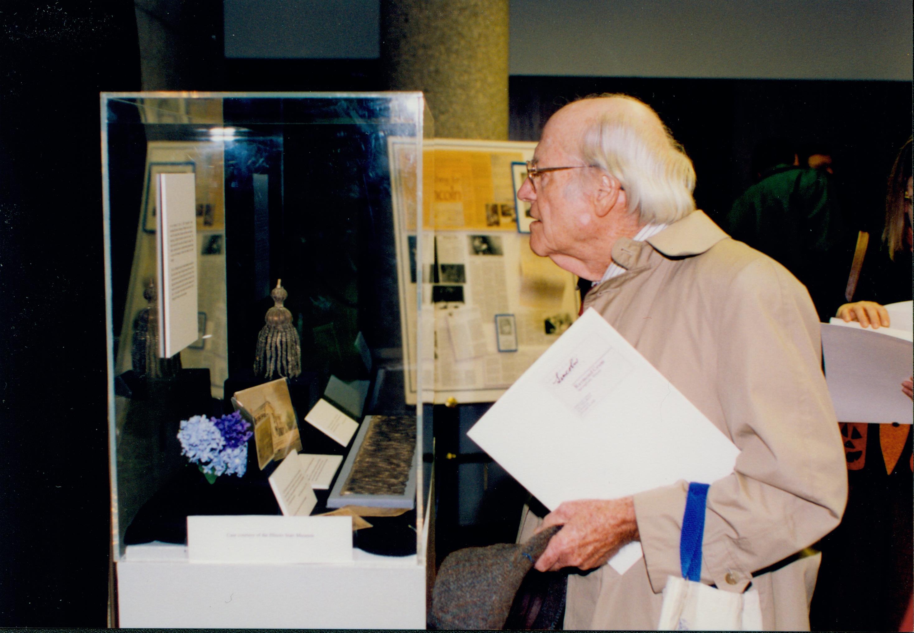 Man holding book looking at exhibit Lincoln Colloquium Lincoln, Colloquium