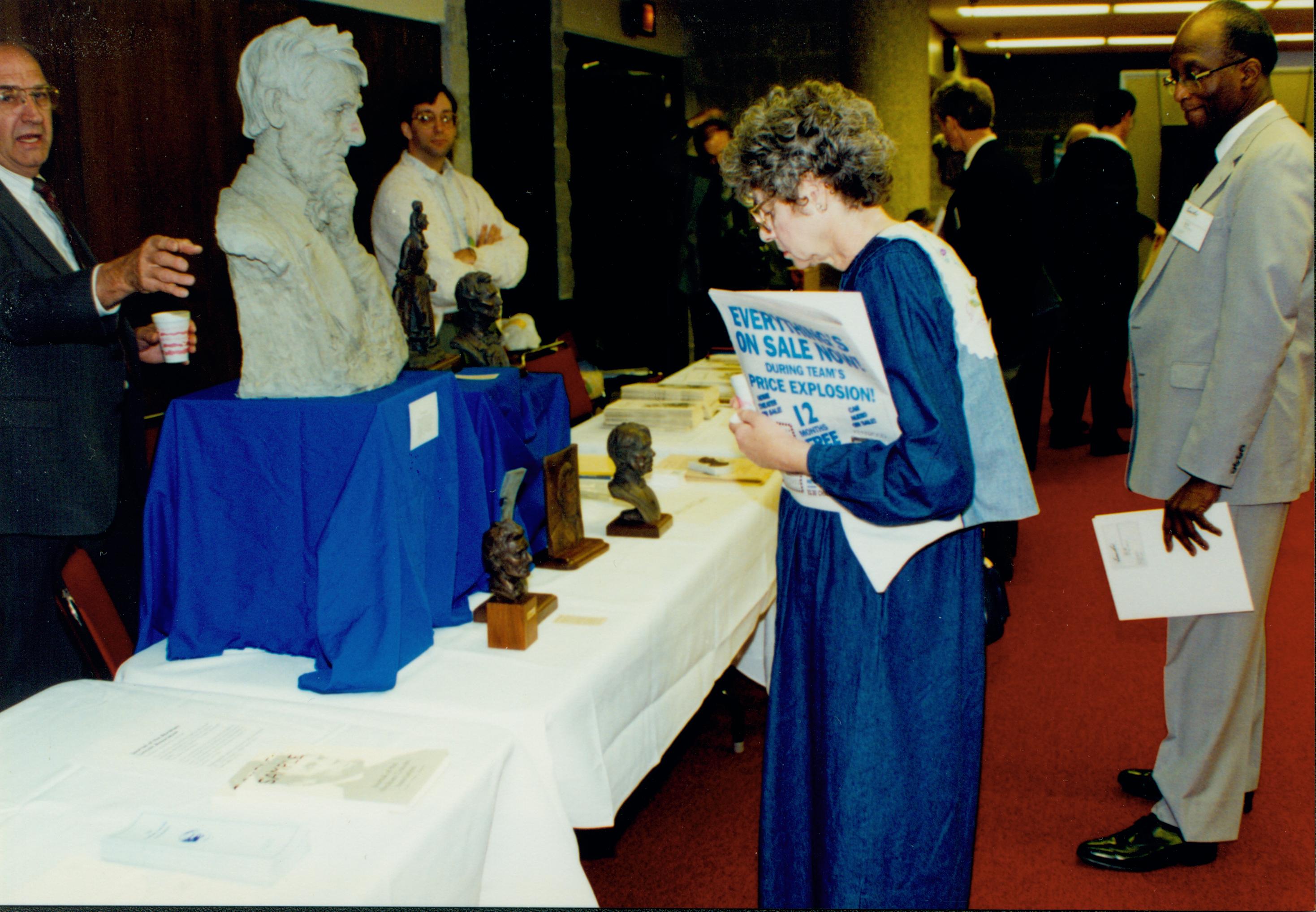 Lady standing looking at Lincoln busts. Lincoln Colloquium Lincoln, Colloquium