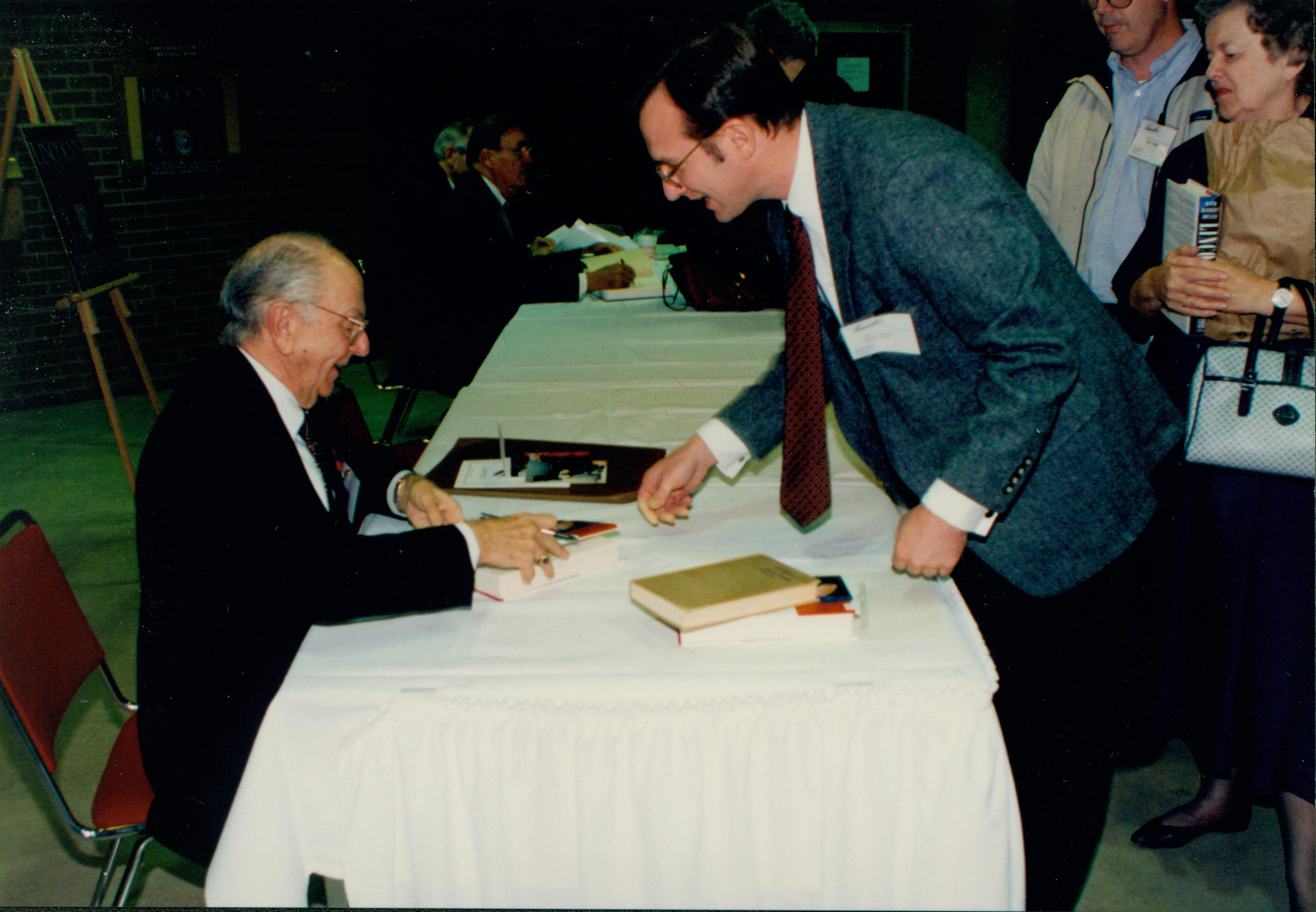 Author signing book for man. Lincoln Colloquium Lincoln, Colloquium