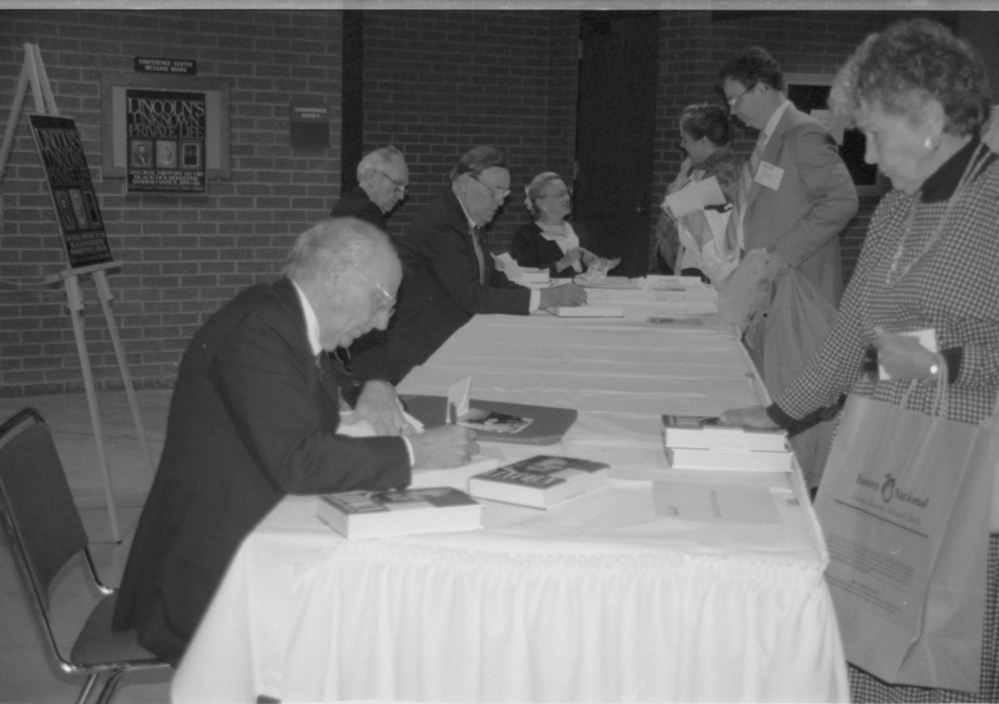 Author signing book for woman. Lincoln Colloquium; 88257 Lincoln, Colloquium