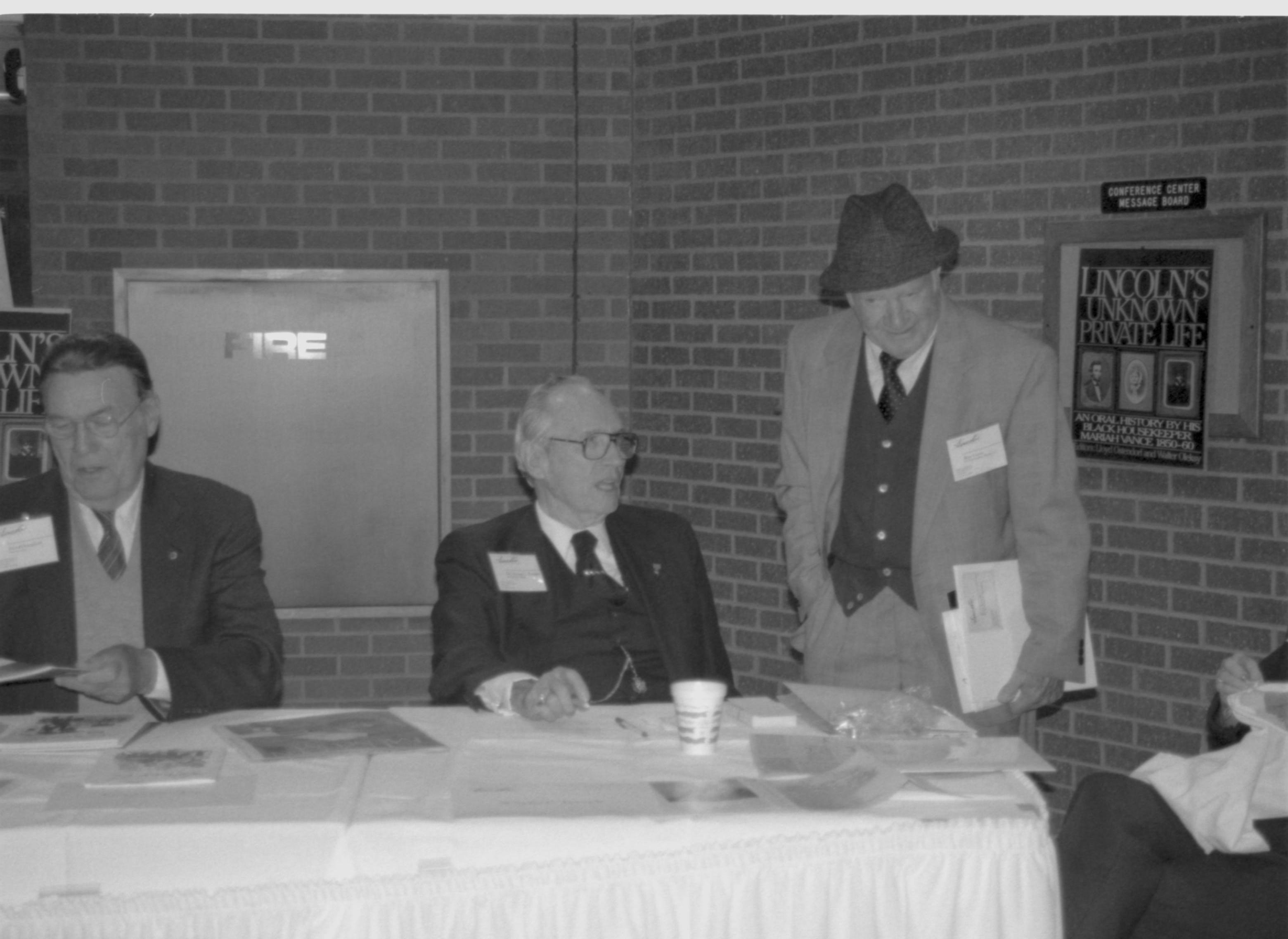 Two authors sitting, man standing. Lincoln Colloquium; 88257 Lincoln, Colloquium