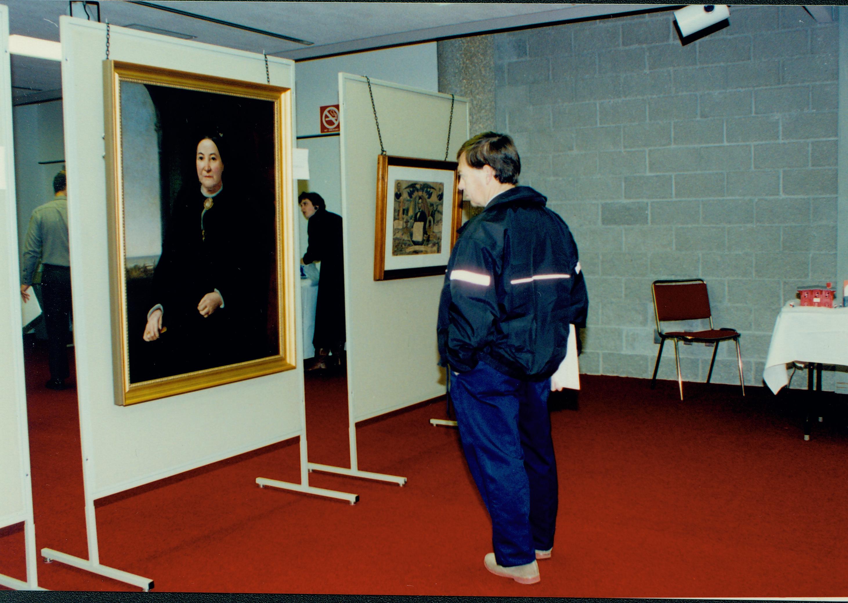 Man looking at large portrait of woman. Lincoln Colloquium; 56936 Lincoln, Colloquium