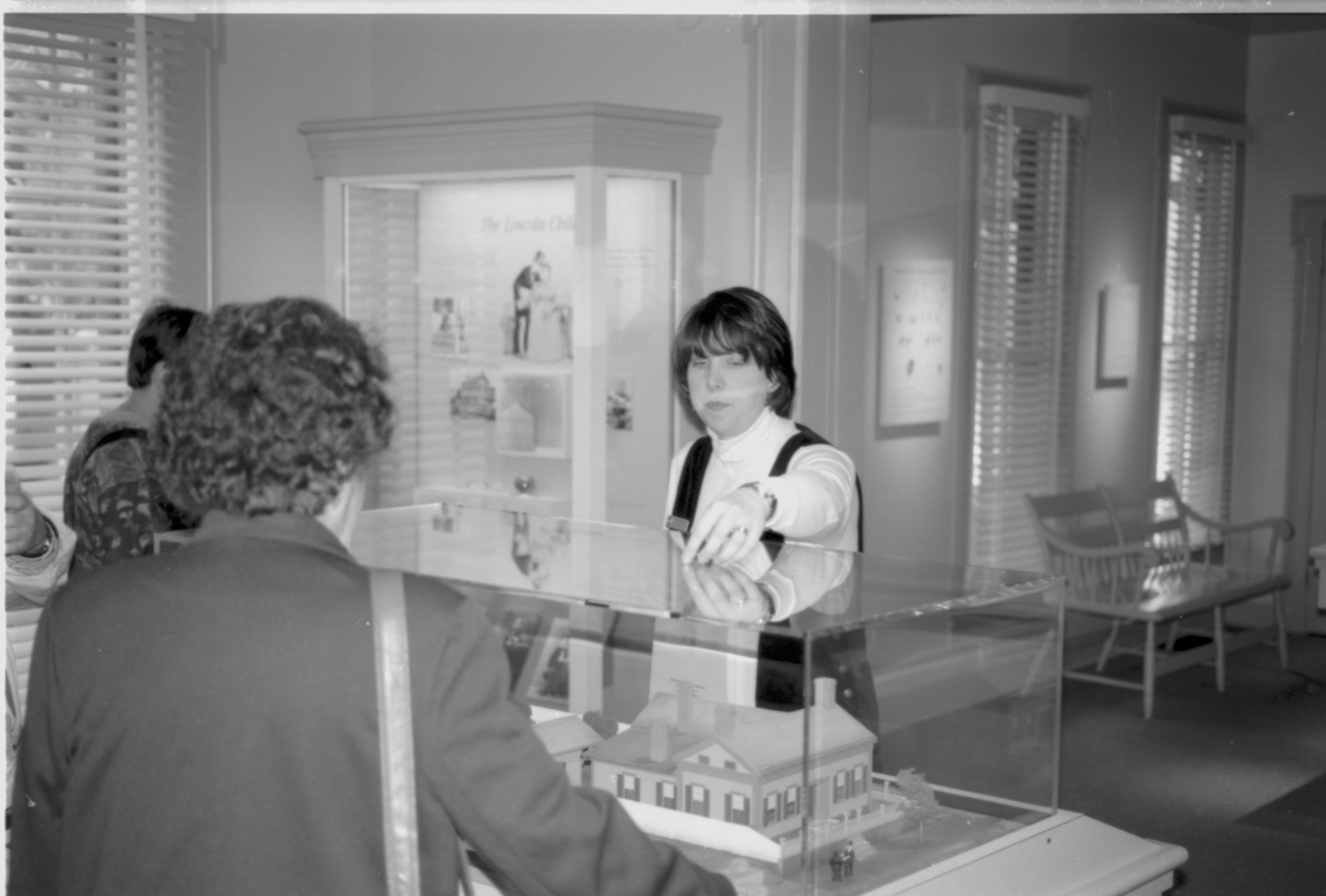 Lady explaining exhibit to visitors in Dean house. Lincoln Colloquium; UIS Roll#1, 4of4 Lincoln, Colloquium