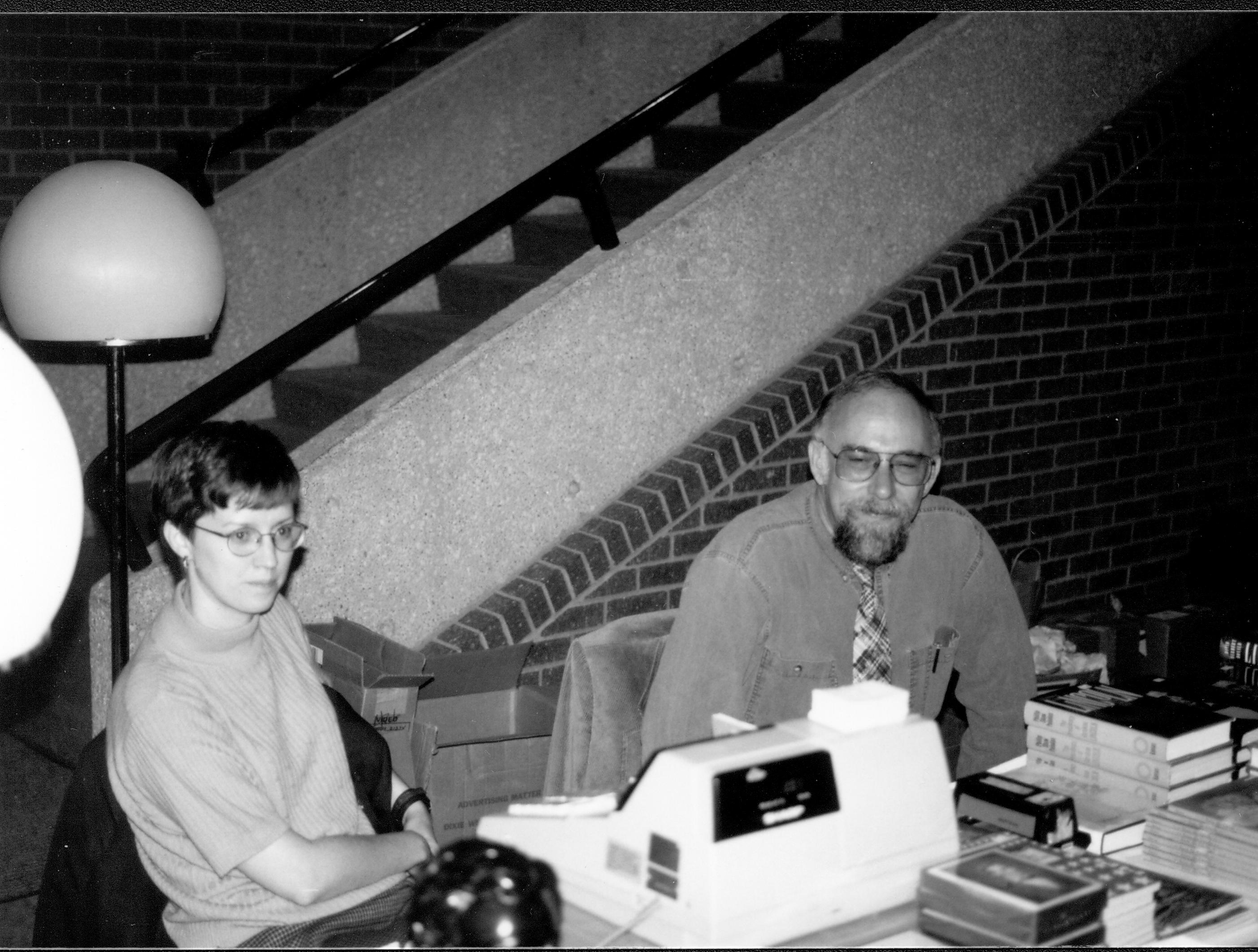 Two people sitting behind cash register. Lincoln Colloquium; UIS Roll#2, 2of4 Lincoln, Colloquium