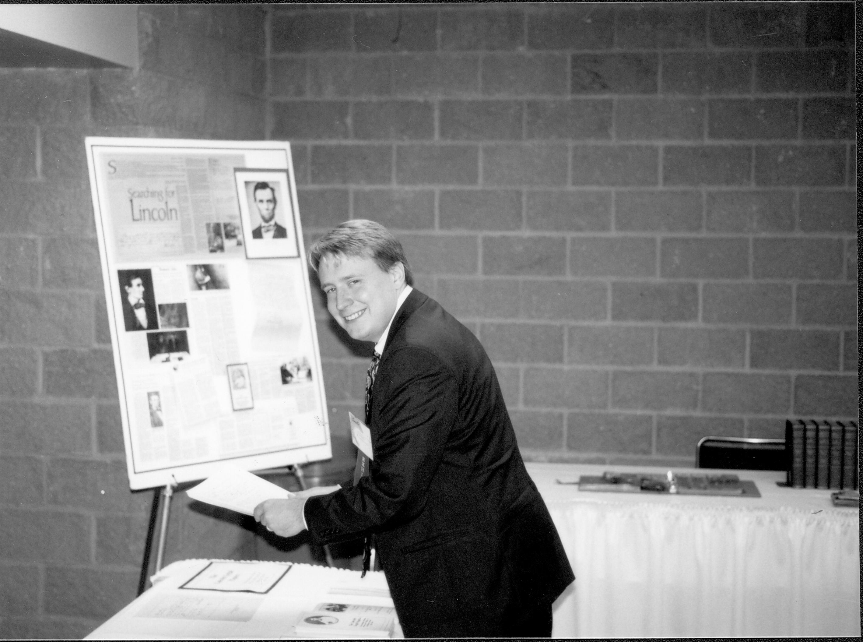 Man picking up literature at exhibit. Lincoln Colloquium; UIS Roll#2, 3of4 Lincoln, Colloquium