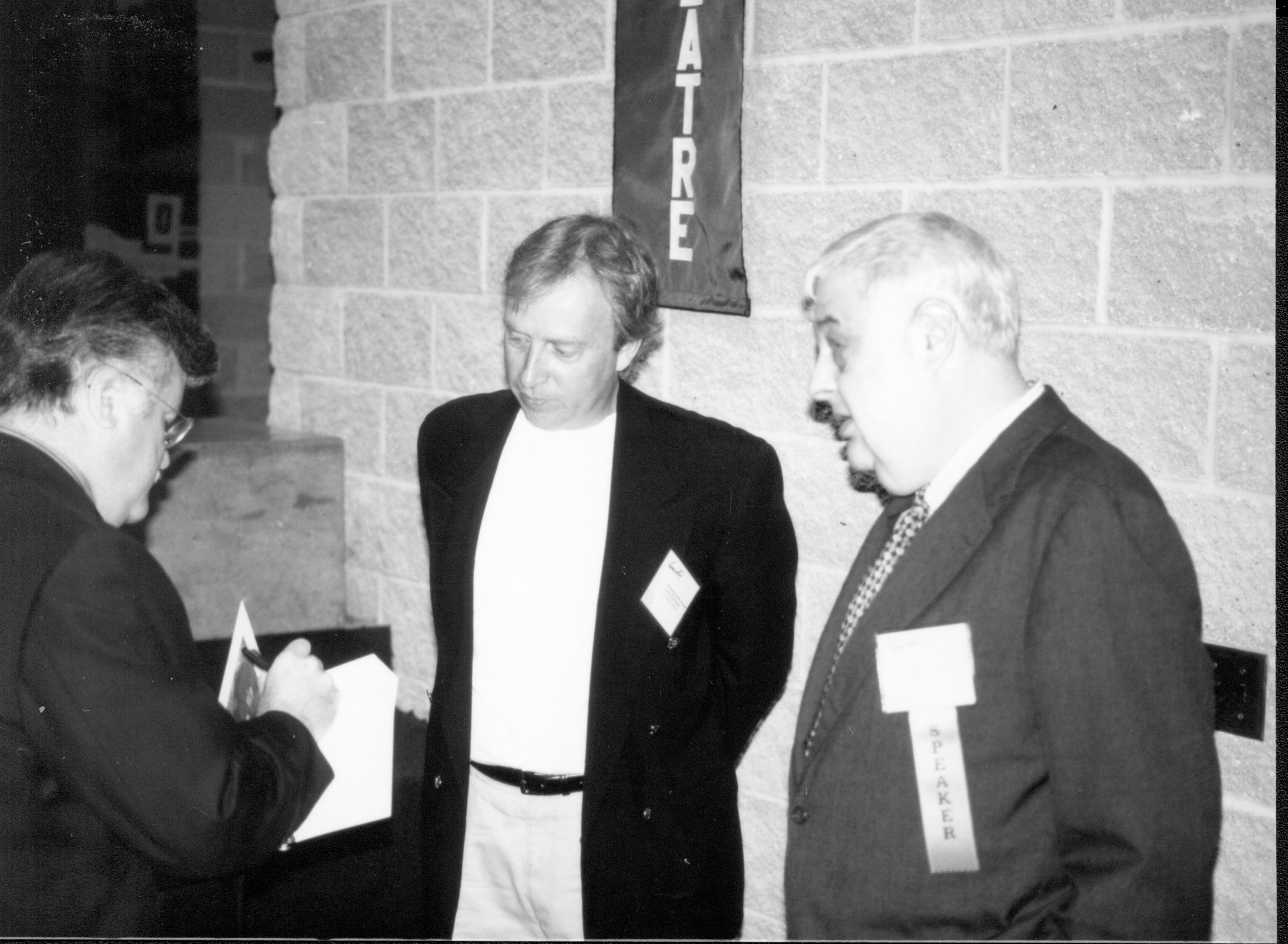 Man signing book, two looking on. Lincoln Colloquium; UIS Roll#2, 1of4 Lincoln, Colloquium