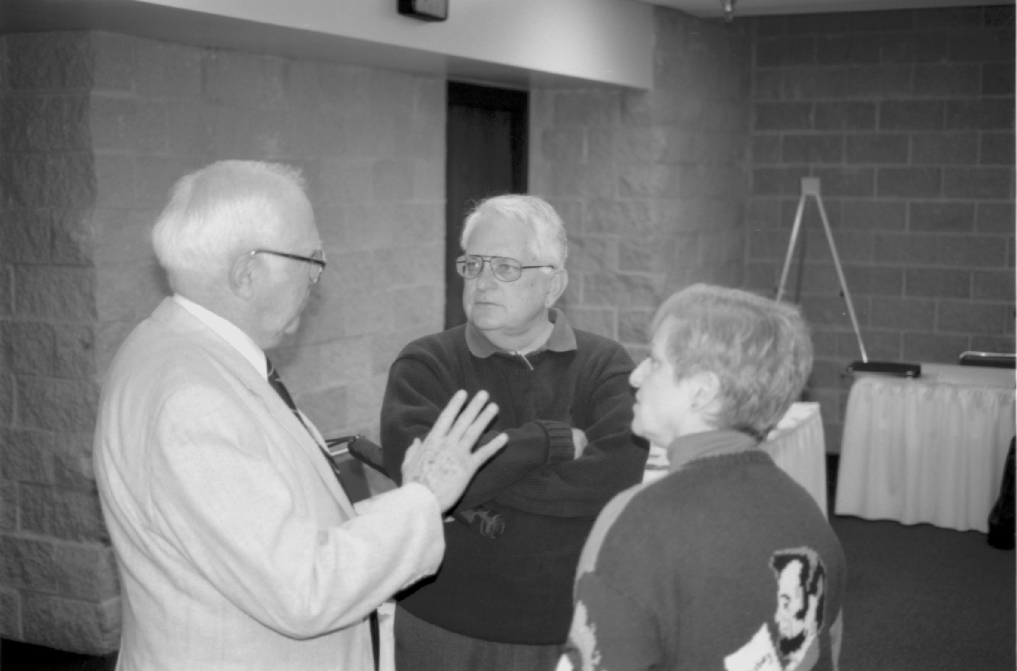 Man in light coat talking to two visitors. Lincoln Colloquium; UIS Roll#2, 4of4 Lincoln, Colloquium