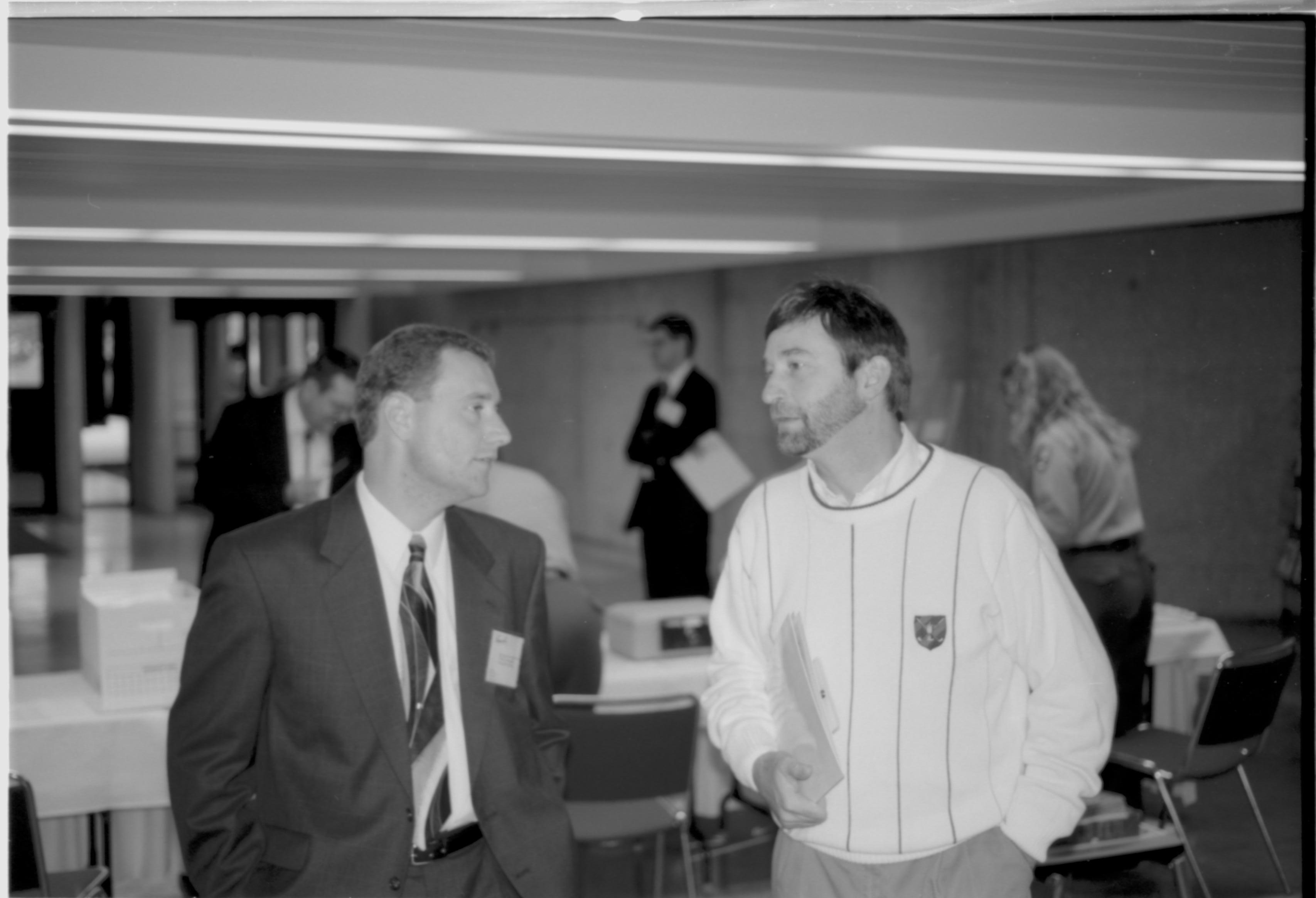 Two men talking, one with hands in pockets. Lincoln Colloquium; UIS Roll#2, 4of4 Lincoln, Colloquium