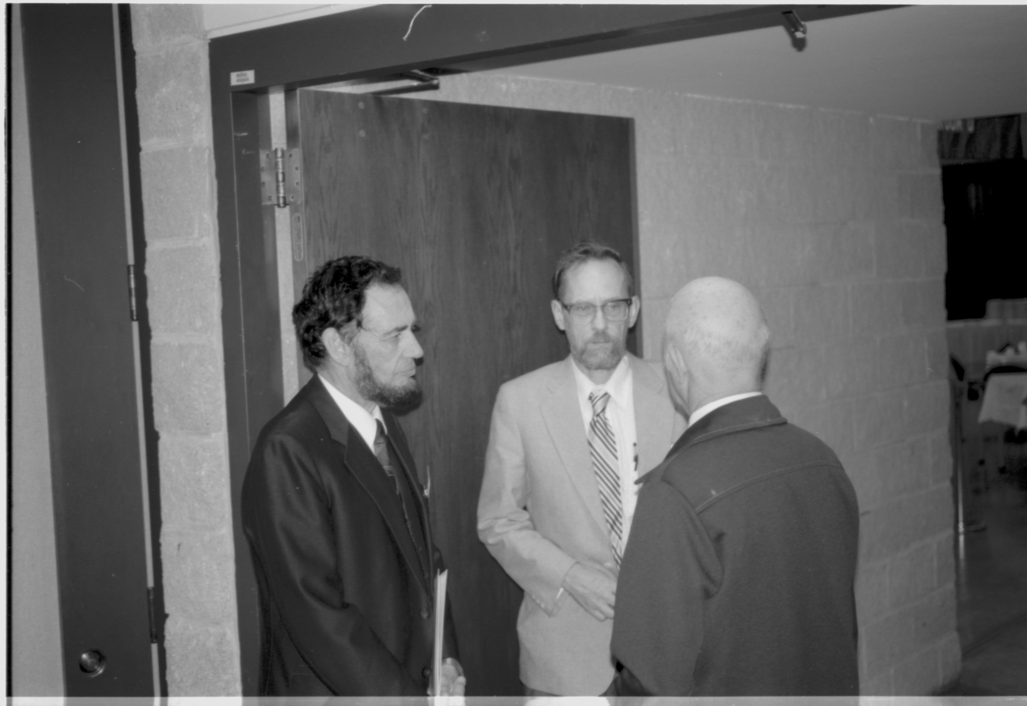 Three men standing in doorway talking. Lincoln Colloquium; UIS Roll#2, 4of4 Lincoln, Colloquium