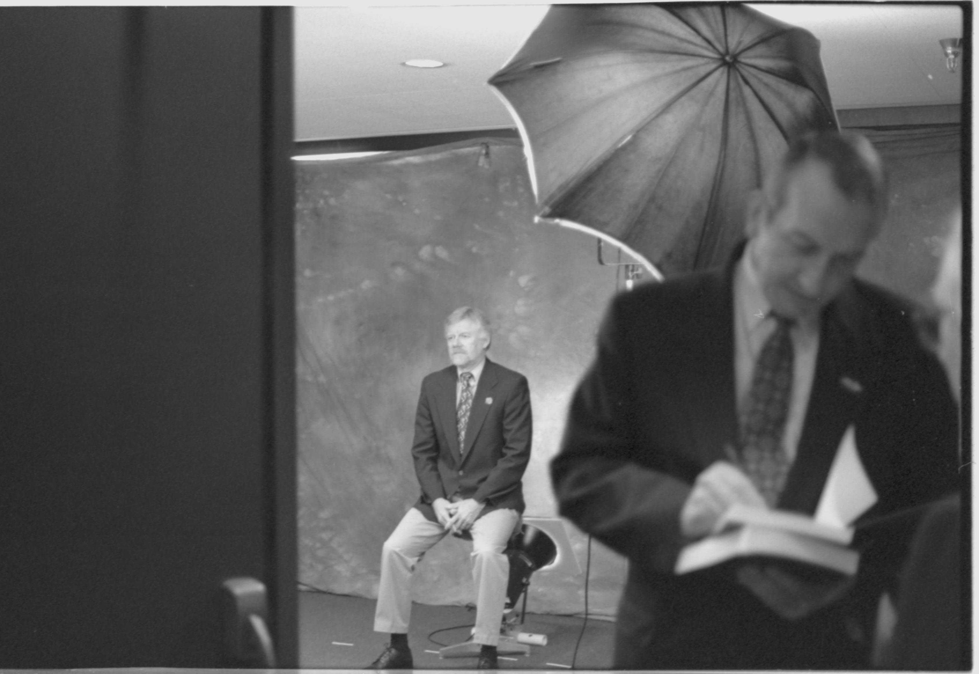 Man being photographed; man signing book. 1-1997 Colloq (b/w) Colloquium, 1997