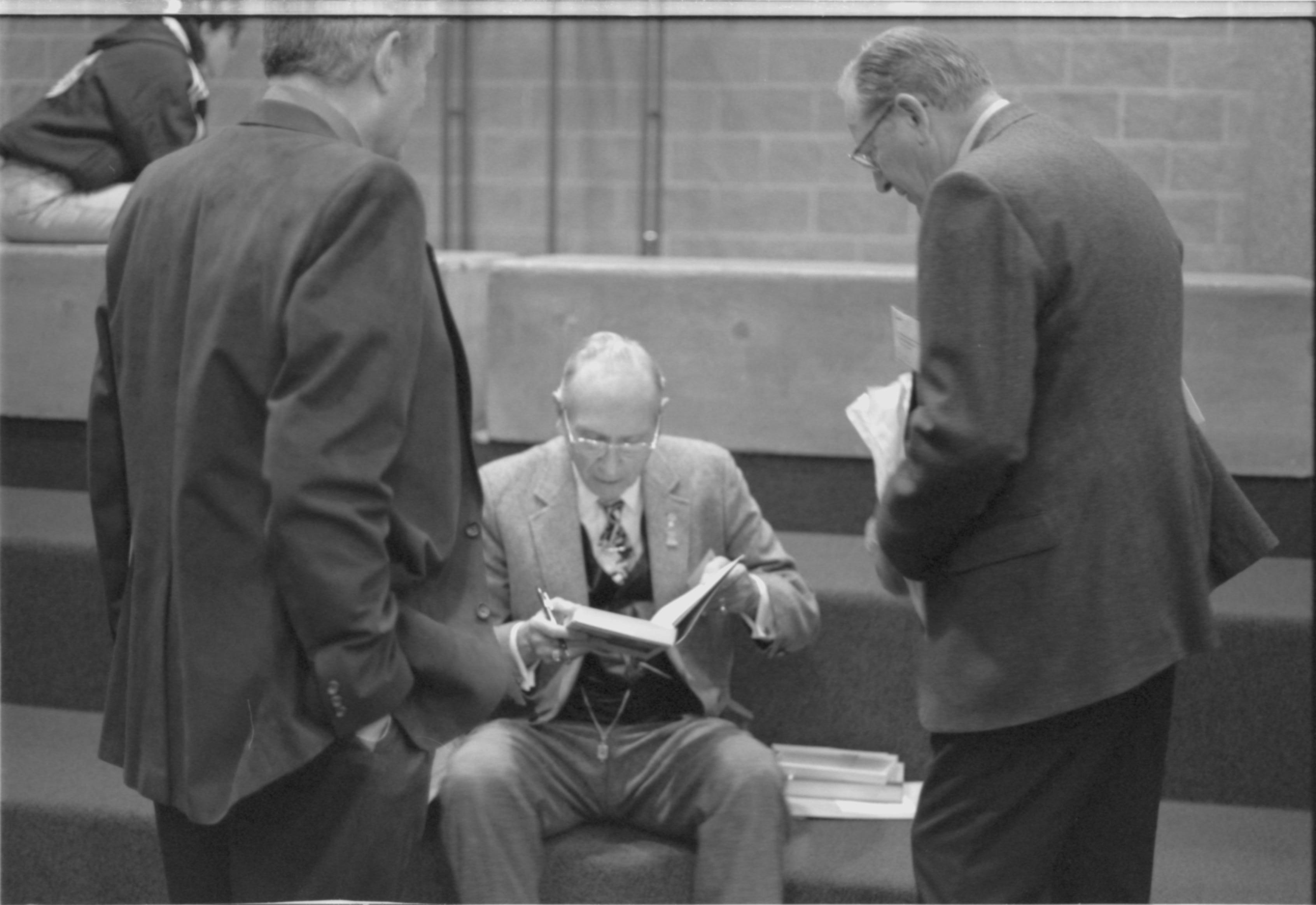 Two men talking to man seated on steps. 1-1997 Colloq (b/w) Colloquium, 1997