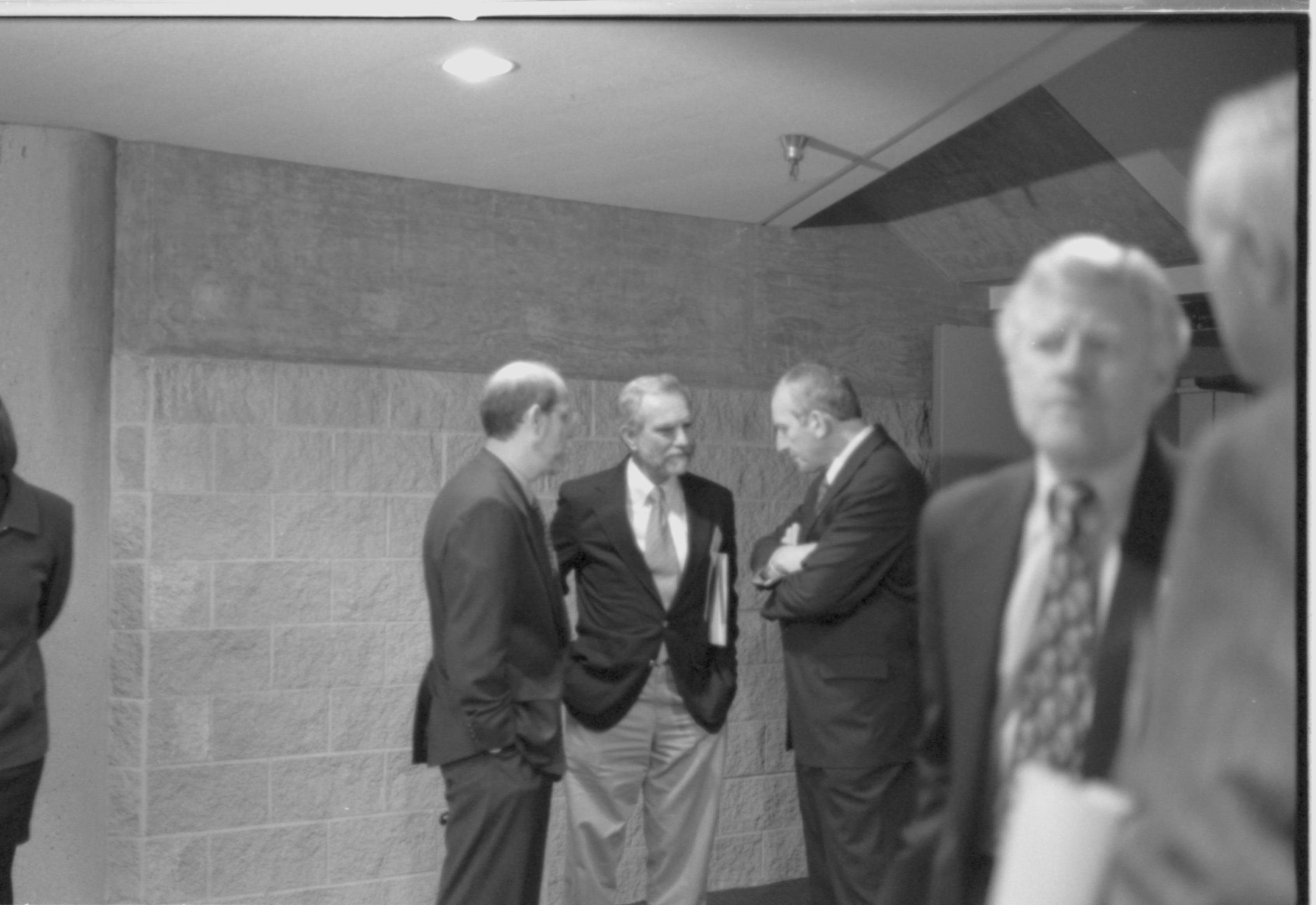 Three men standing in distance talking. 1-1997 Colloq (b/w) Colloquium, 1997