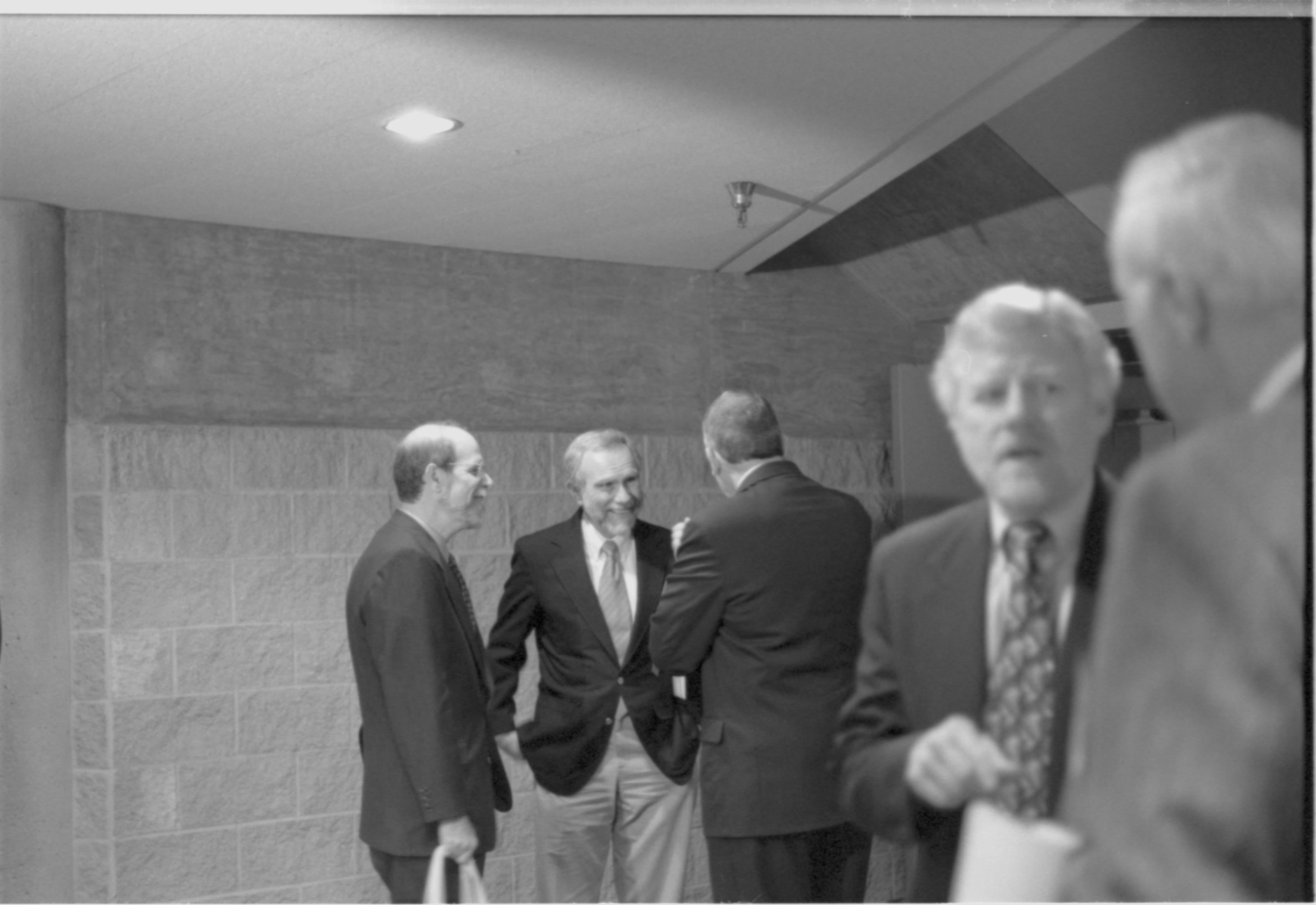 Three men standing in distance talking. 1-1997 Colloq (b/w) Colloquium, 1997