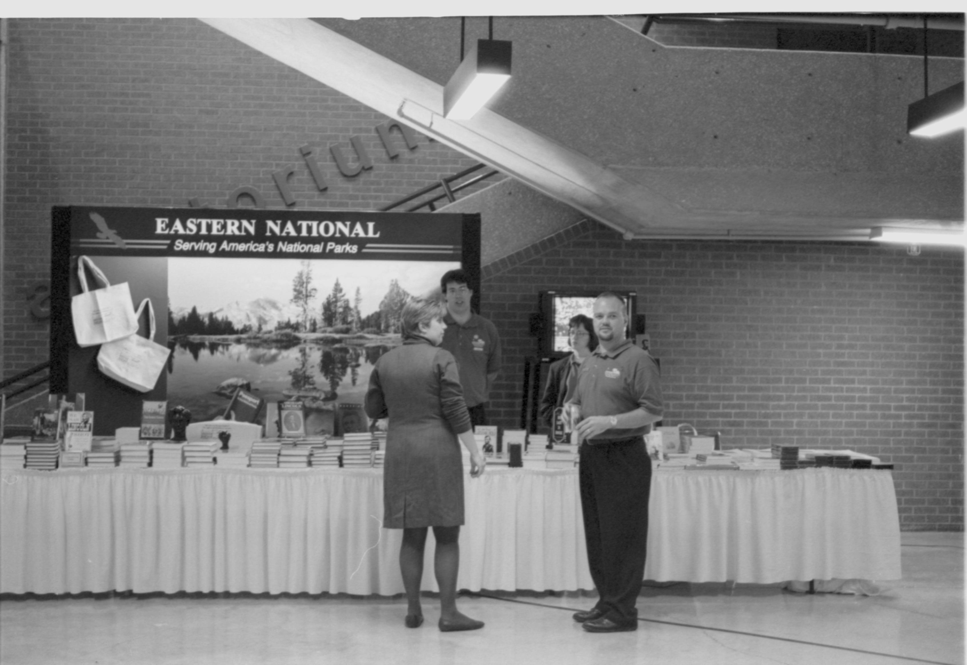 Man and lady in front of Eastern National booth 3-1997 Colloq (b/w); 4 Colloquium, 1997