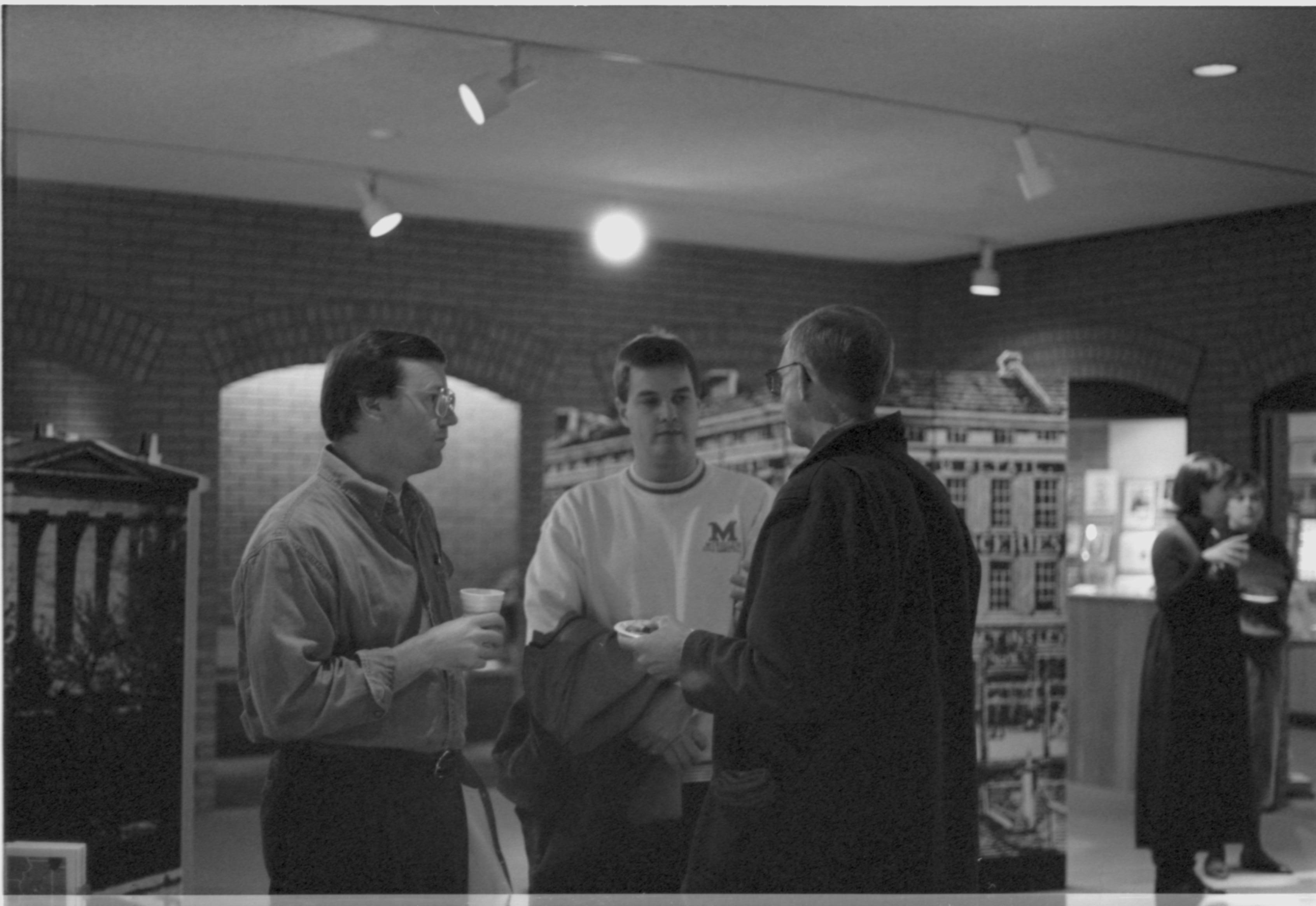 Three men talking in VC with refreshments. 3-1997 Colloq (b/w); 13 Colloquium, 1997