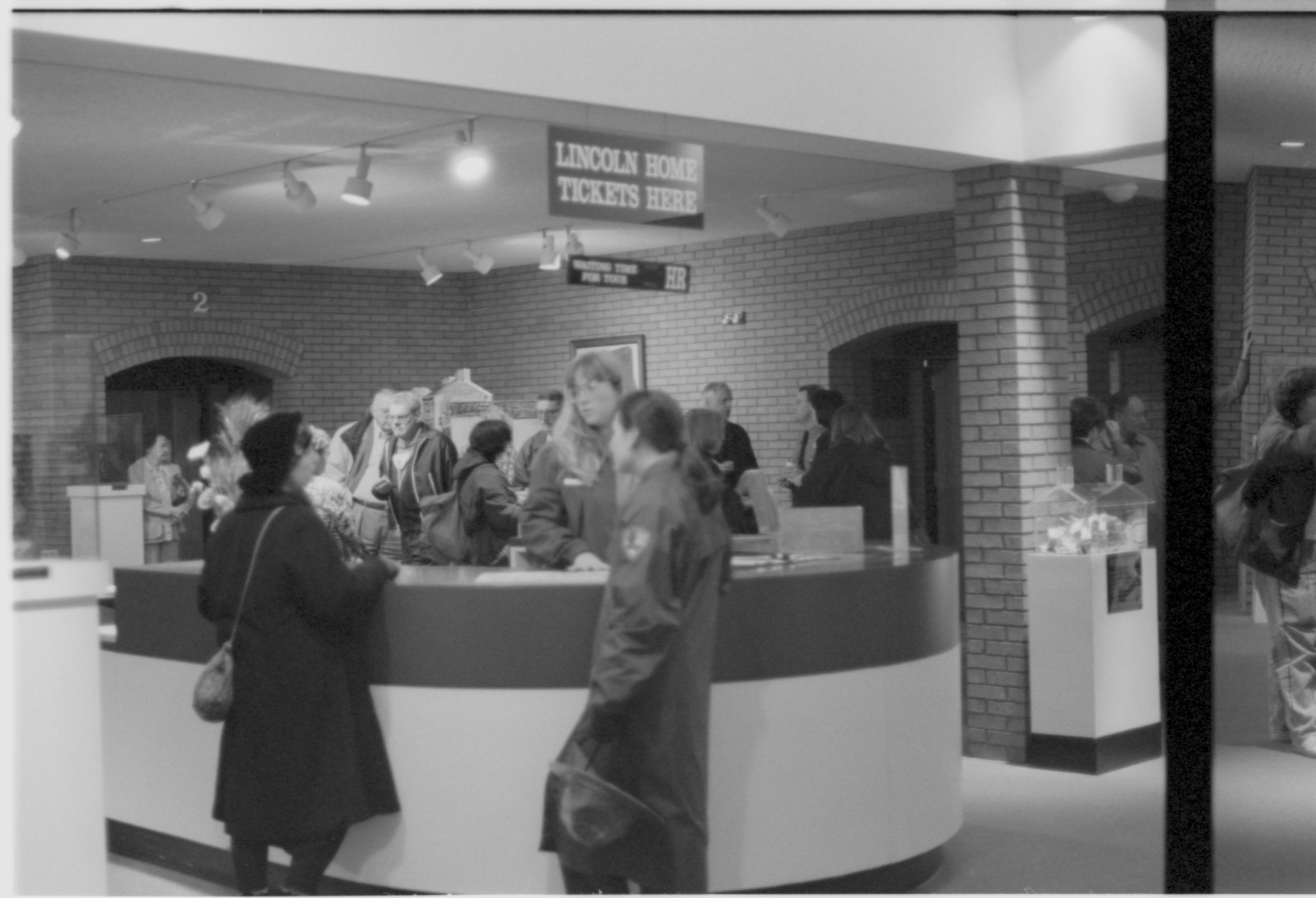 People standing at information deak. 3-1997 Colloq (b/w); 17 Colloquium, 1997