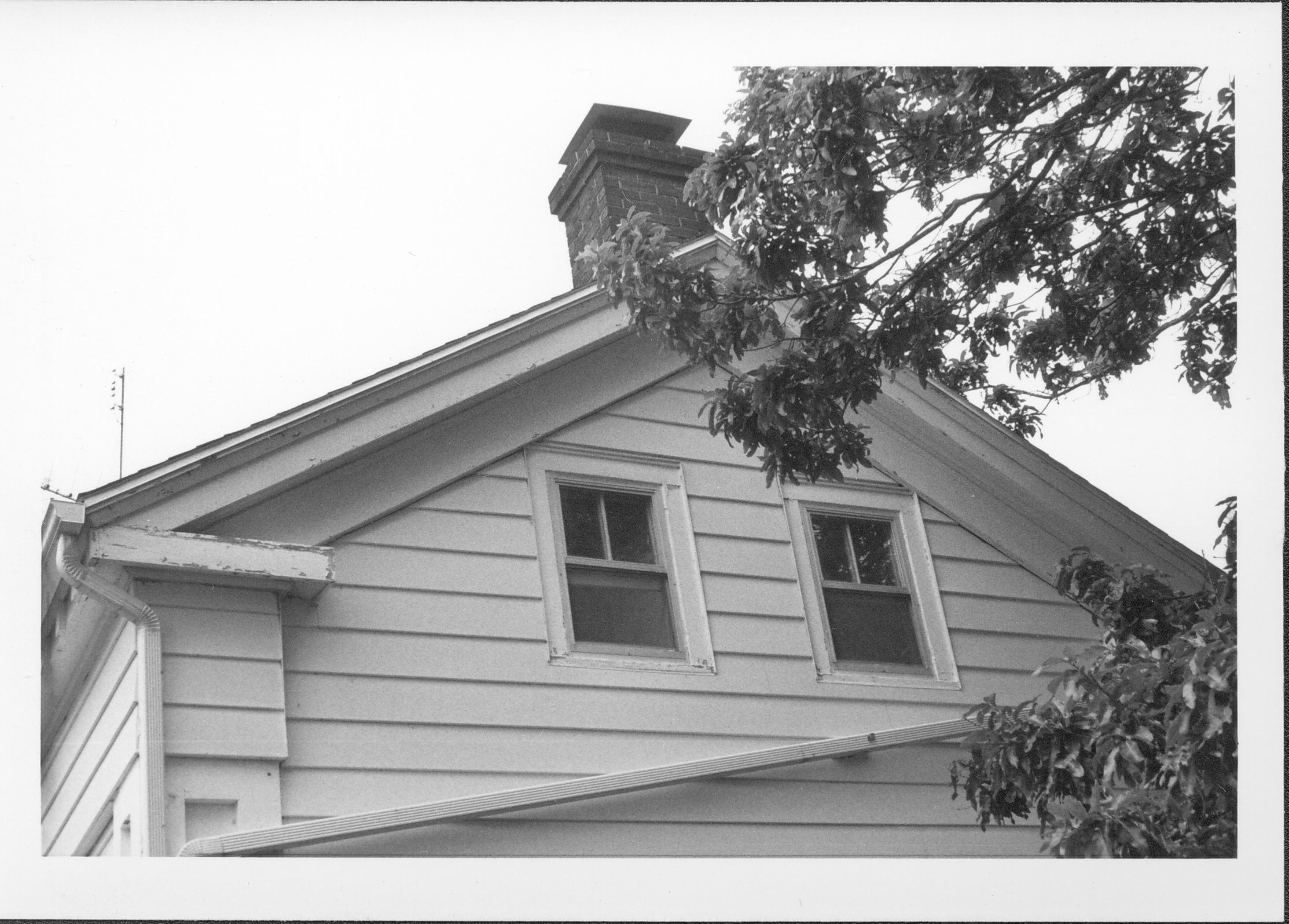 End view of white house with guttering angling down. Gardner-McMillan