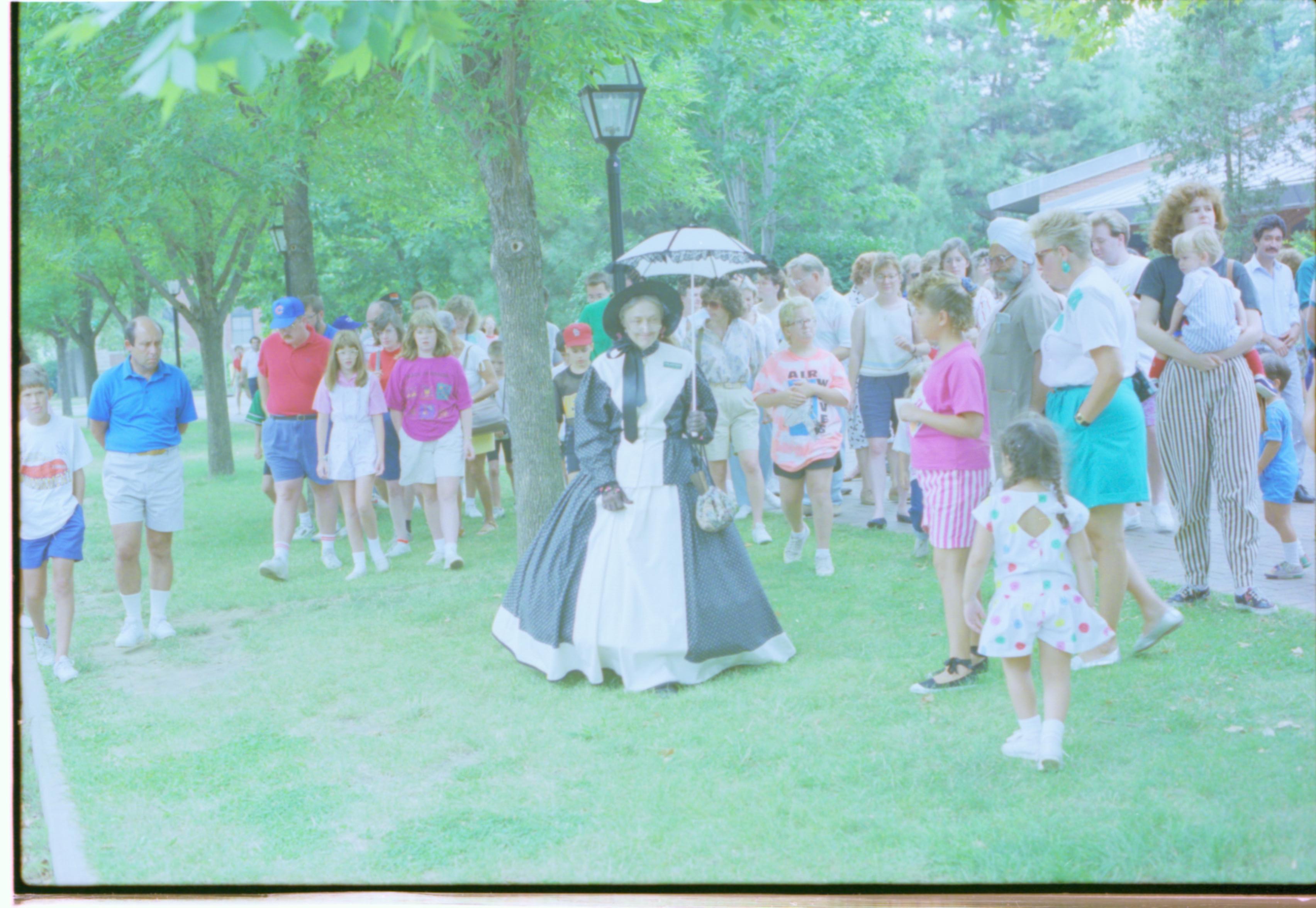 Lady in period dress talking to people. Interpretation