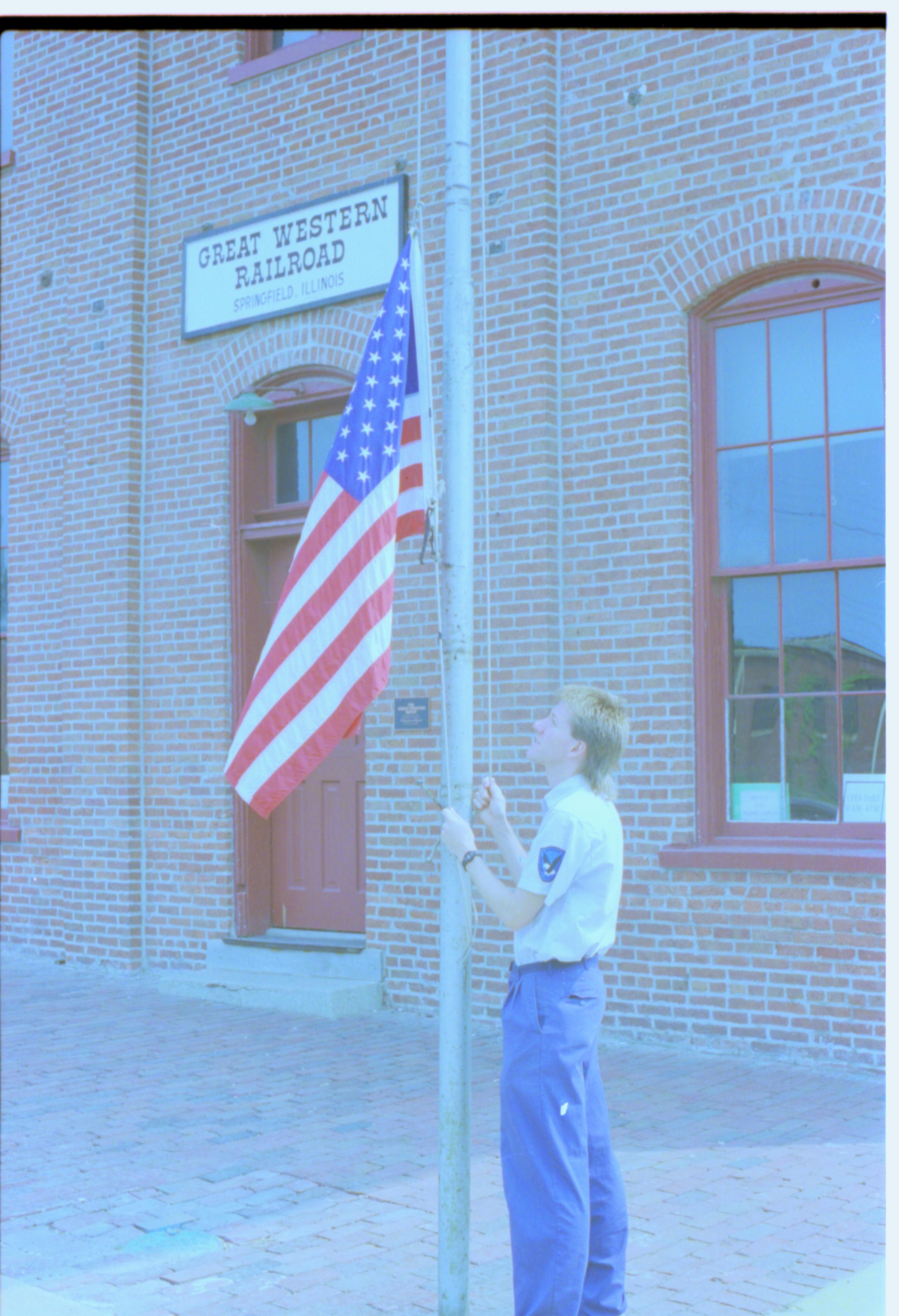 Man raising flag. Great Western Train Depot, Train Station