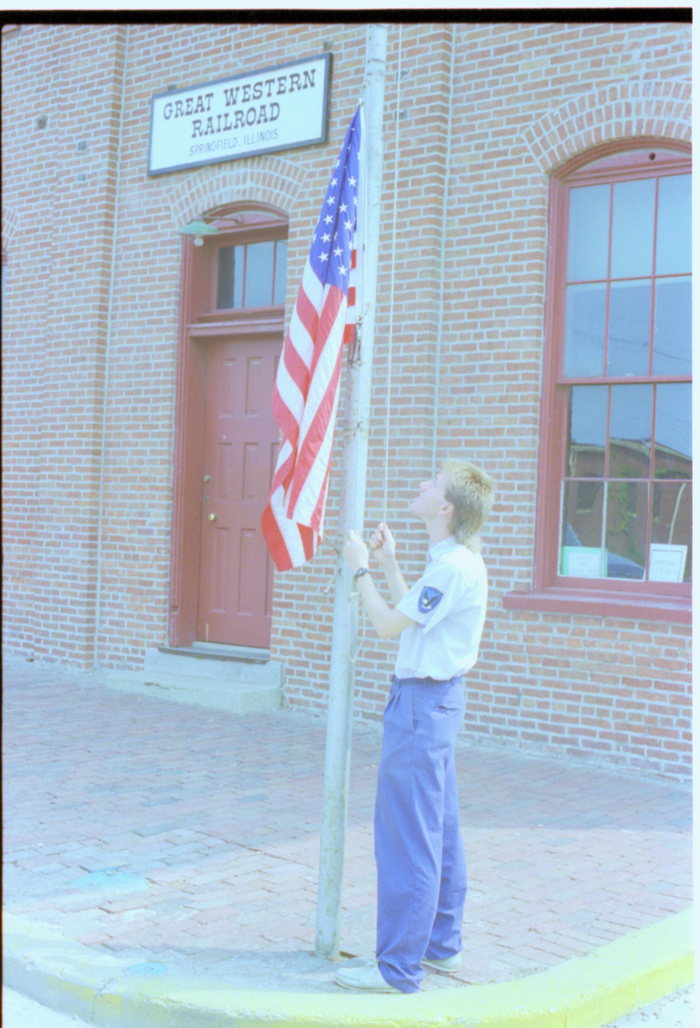 Man raising flag. Great Western Train Depot, Train Station