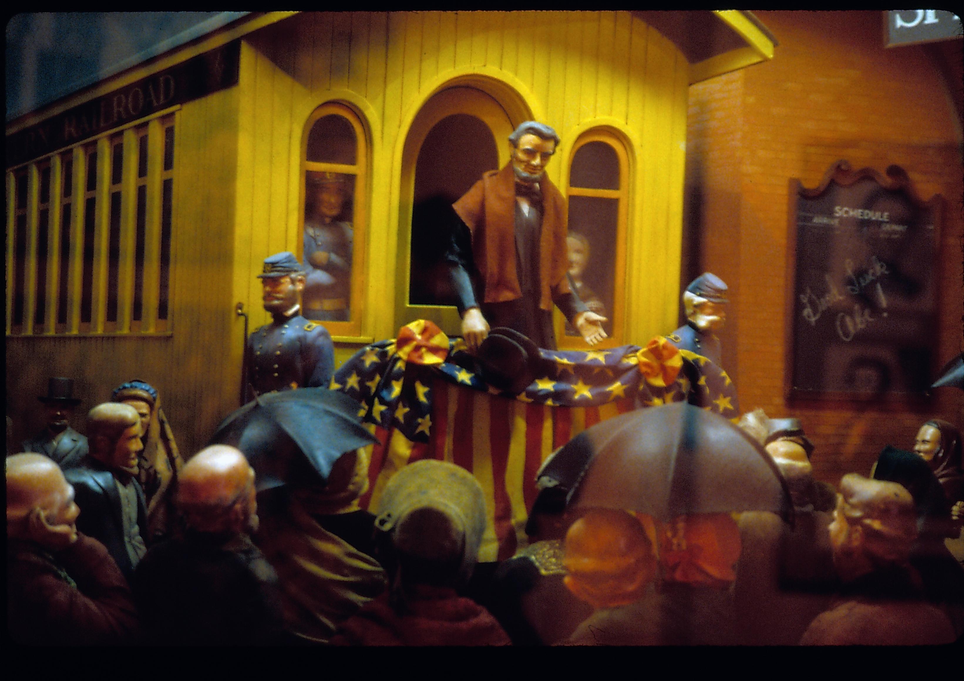 Diorama of man standing on back of train car. Great Western Depot, Train Station