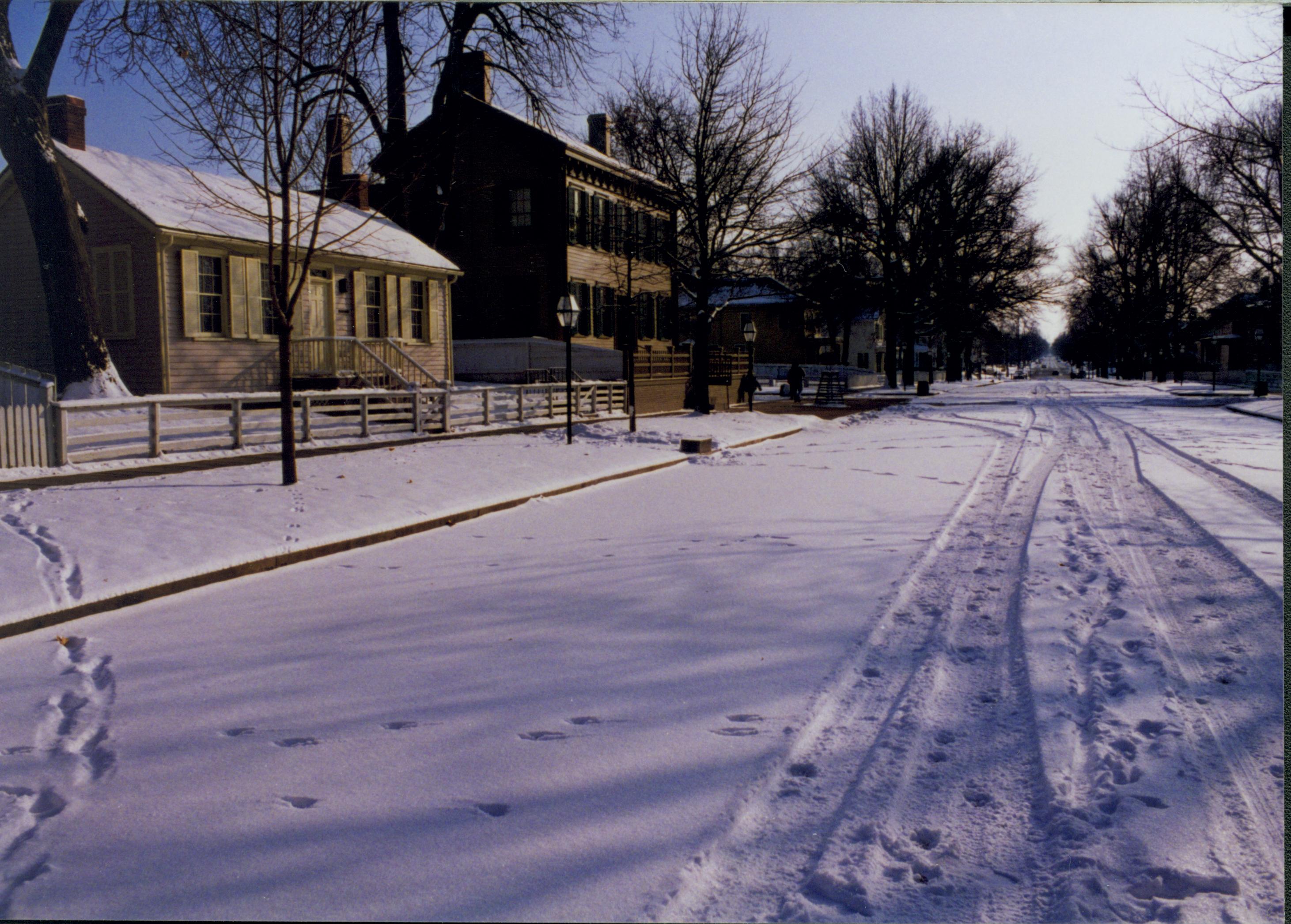 Lincoln neighborhood in the snow, along 8th Street.  Corneau House on left, Lincoln Home in center.  Animal tracks and Cushman/Maintenance vehicle tracks visible. Looking South/Southeast on 8th Street snow, Lincoln Home, Corneau, 8th Street