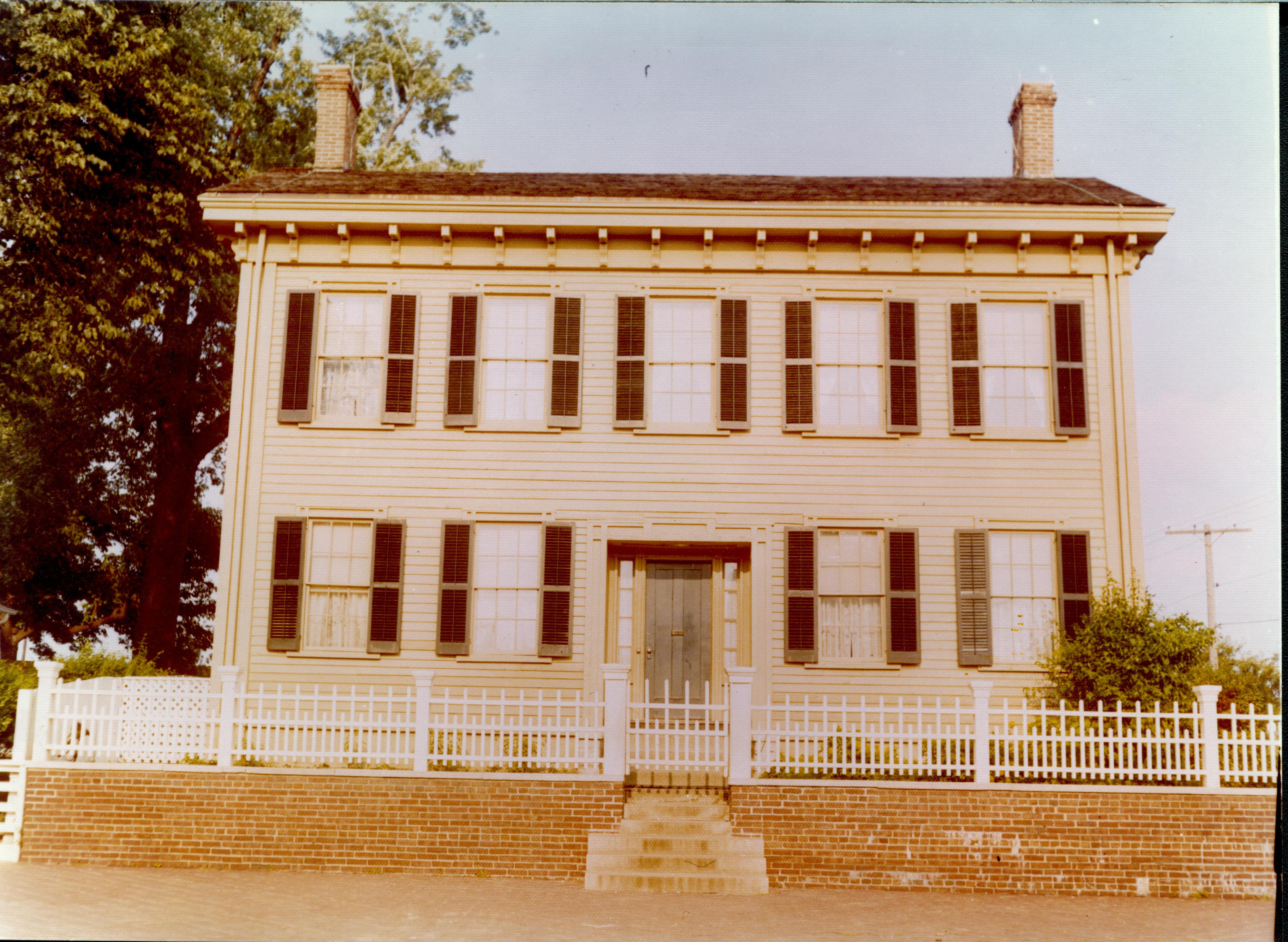 Lincoln Home west (front) elevation in summer. Utility pole in background right with lines leading from it Looking east from 8th Street Lincoln Home, 8th Street, brick plaza, utility lines, utility pole