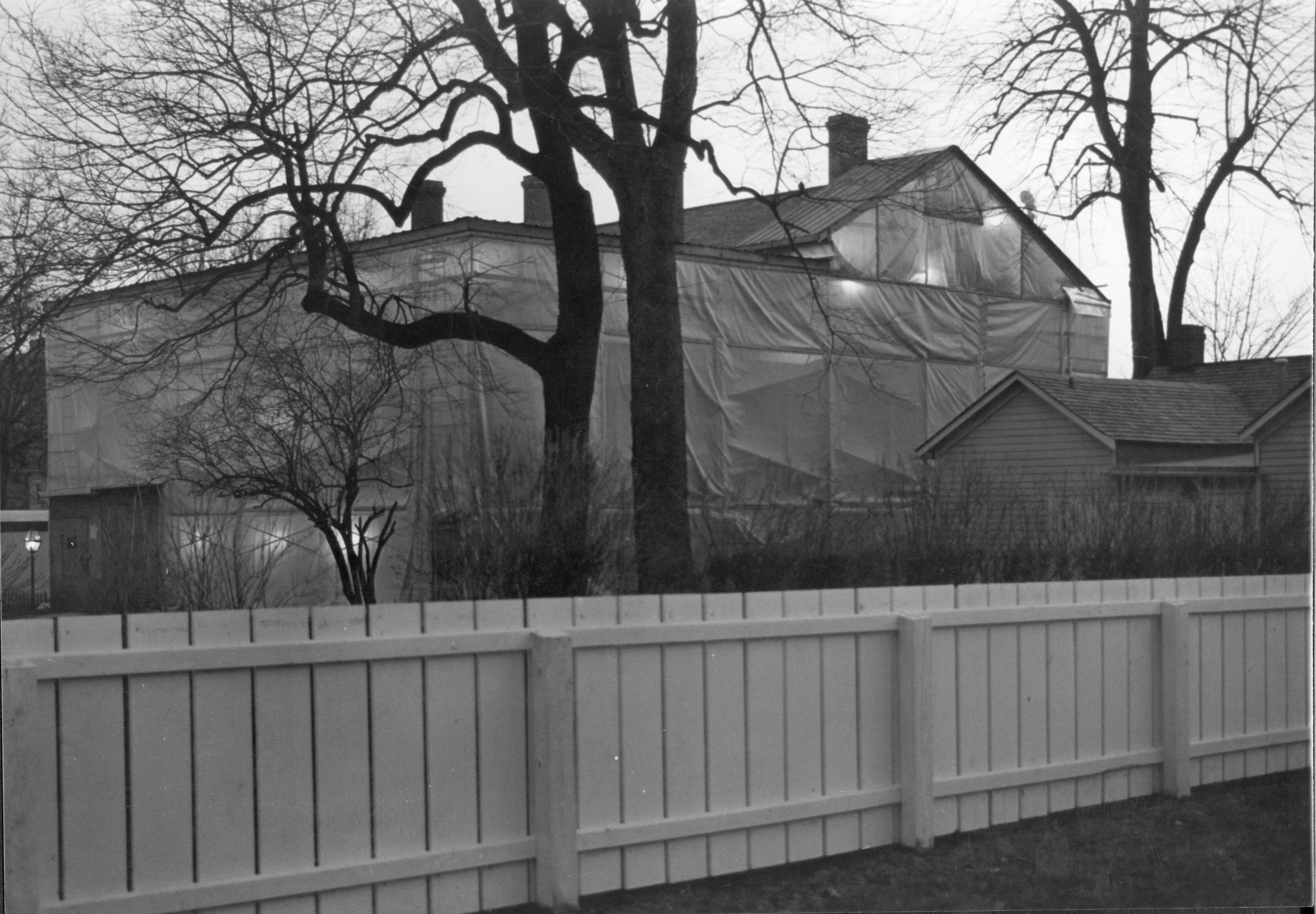 In an unusual procedure, an enclosure system was erected around the Lincoln Home to allow work to continue during the winter. The enclosure protected the work area fom wind and snow; it also provided a sufficiently warm environment for curing of plaster a 21-11 Lincoln, Home, Restoration, tent, north