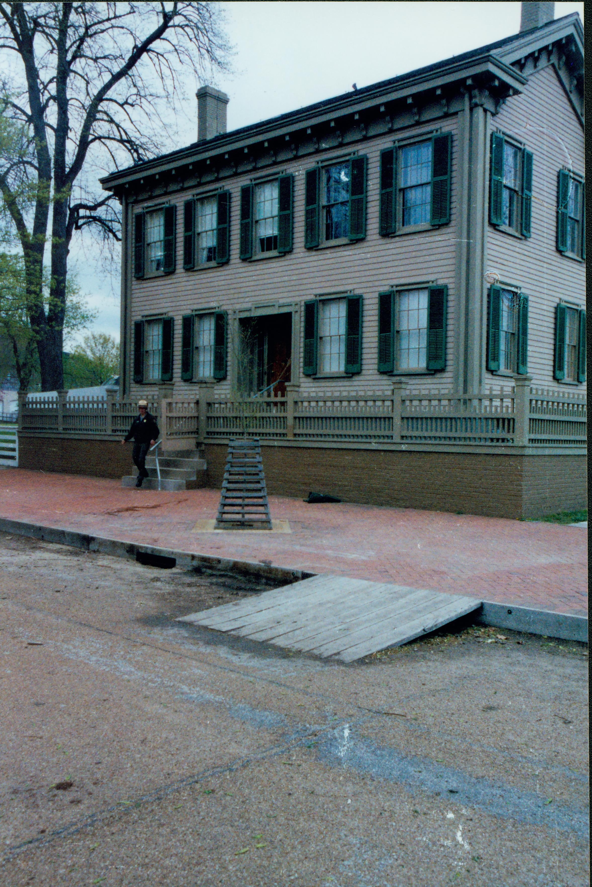 Elm tree replacement - Job completed with new elm tree planted on brick plaza in front of Lincoln Home. Cage replaced, bricks replaced in plaza. Ranger ? comes down steps. Looking Northeast from 8th and Jackson Street intersection Elm tree, Lincoln Home, brick plaza, staff