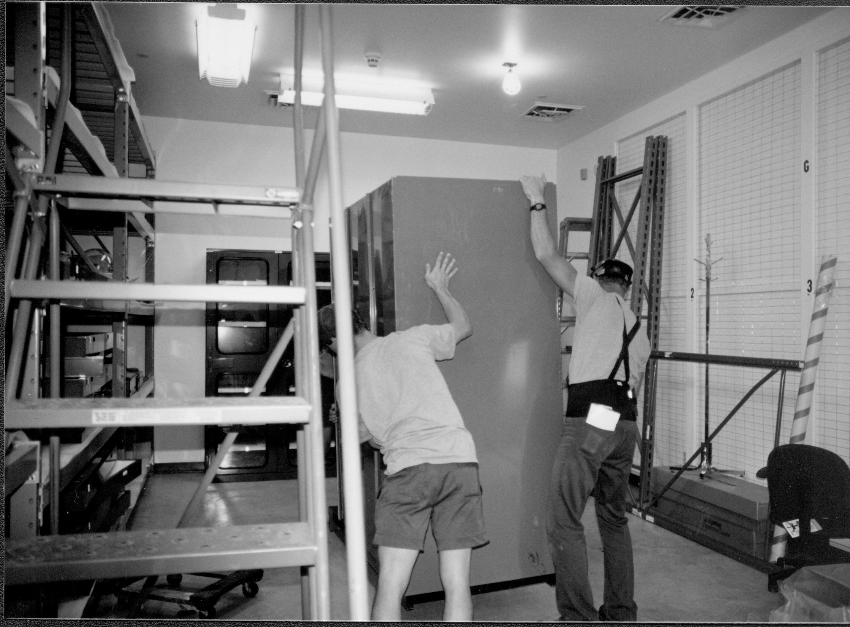 Moving 2nd of the large gray storage cabinets into the new storage area Lincoln Home NHS, CRS Collection Move, Facing East Wall, Roll N10, exp 7 sheet 2 of 7 Arnold Barn, storage