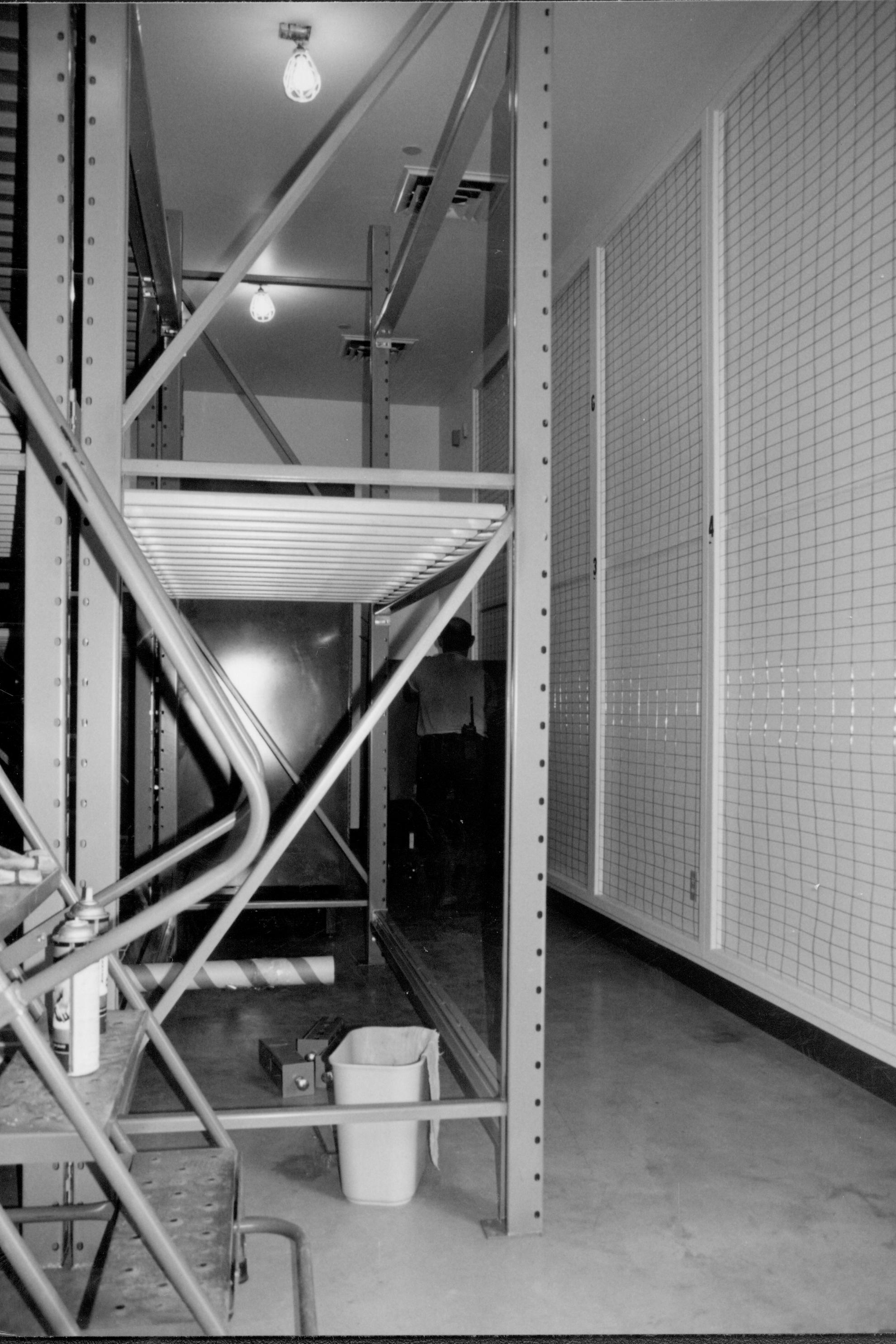 Standing at entrance (Southwest), looking along South aisle. South (art) wall is at right of photo. Book cabinet installed  Lincoln Home NHS, CRS Collection Move, South Wall, Roll N10, exp 17 sheet 5 of 7 Arnold Barn, storage, artifacts