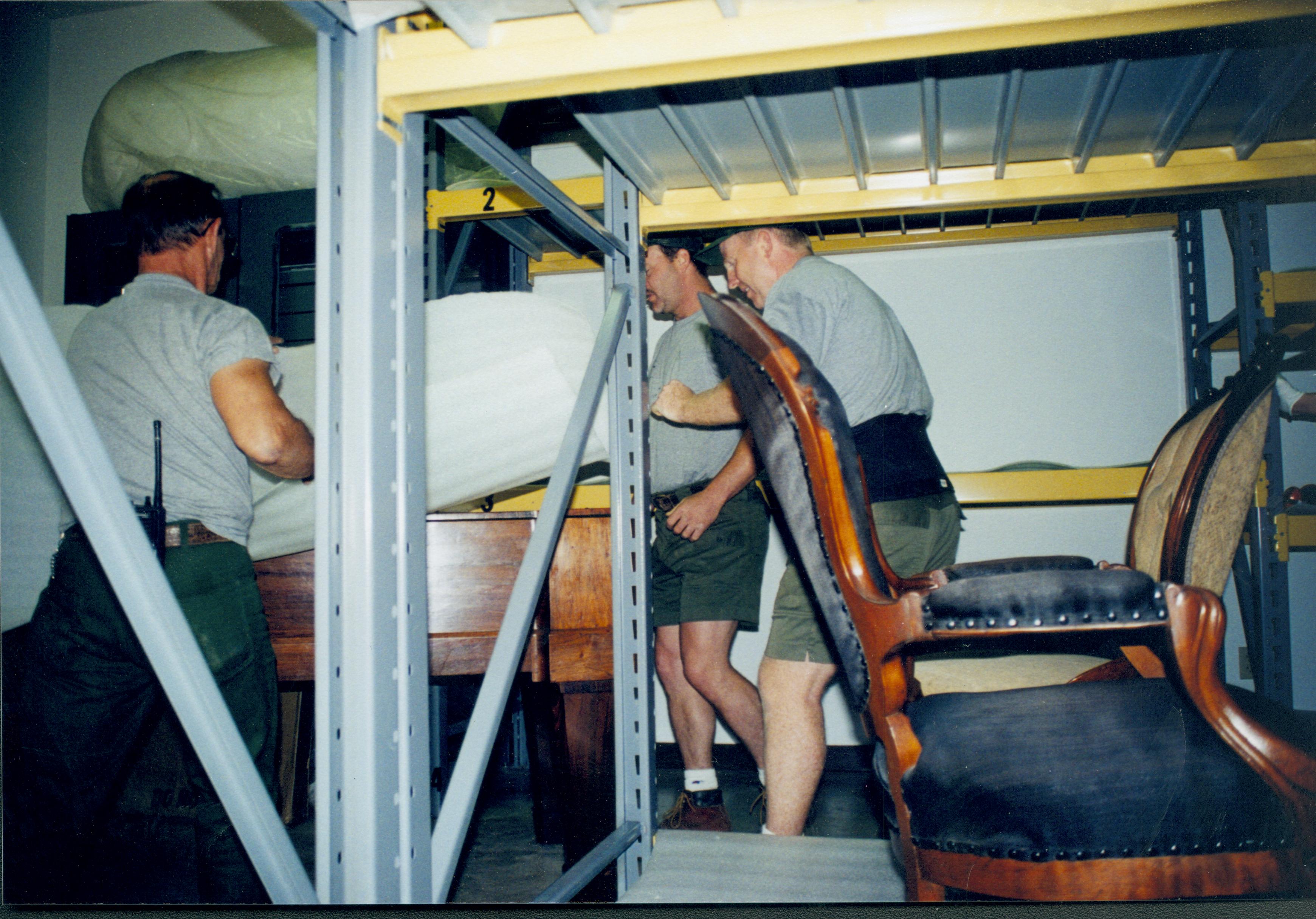 Members of maintenance mving piano into its new position in the Arnold Barn storage space. Photo taken from South aisle, looking at the North wall (A3 storage space) Lincoln Home NHS, 1998 CRS Collection Move, Roll N7, exp 15 sheet 5 of 9 Arnold Barn, storage room