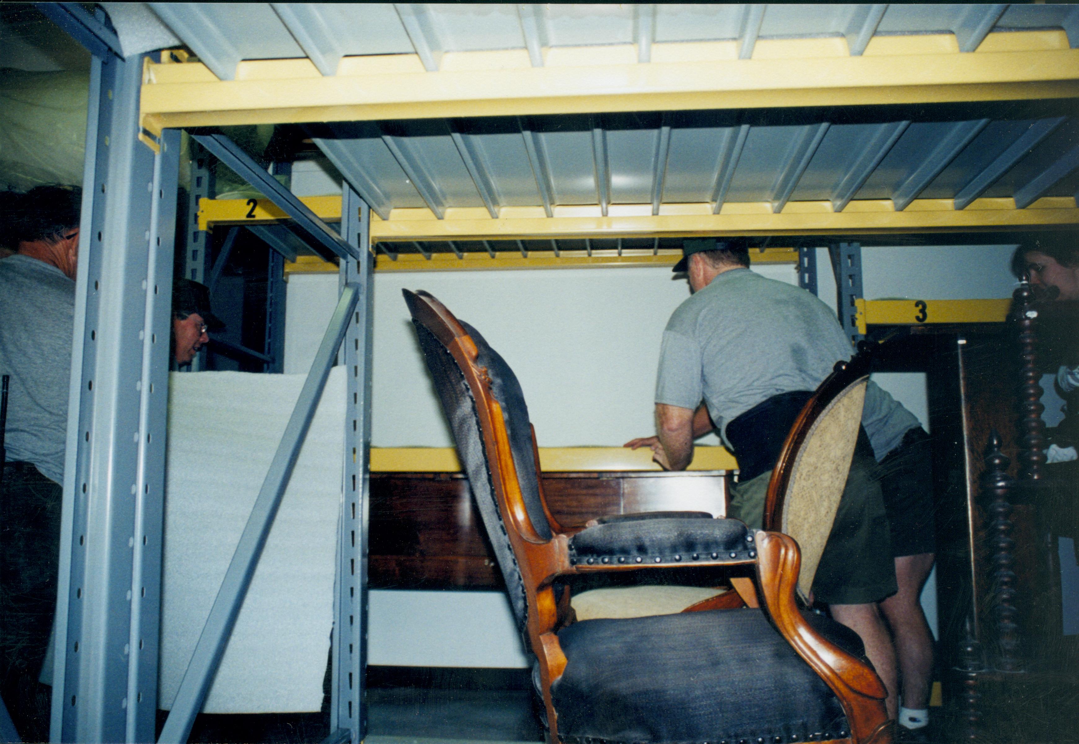 Members of maintenance mving piano into its new position in the Arnold Barn storage space. Photo taken from South aisle, looking at the North wall (A3 storage space) Lincoln Home NHS, 1998 CRS Collection Move, Roll N7, exp 16 sheet 6 of 9 Arnold Barn, storage room