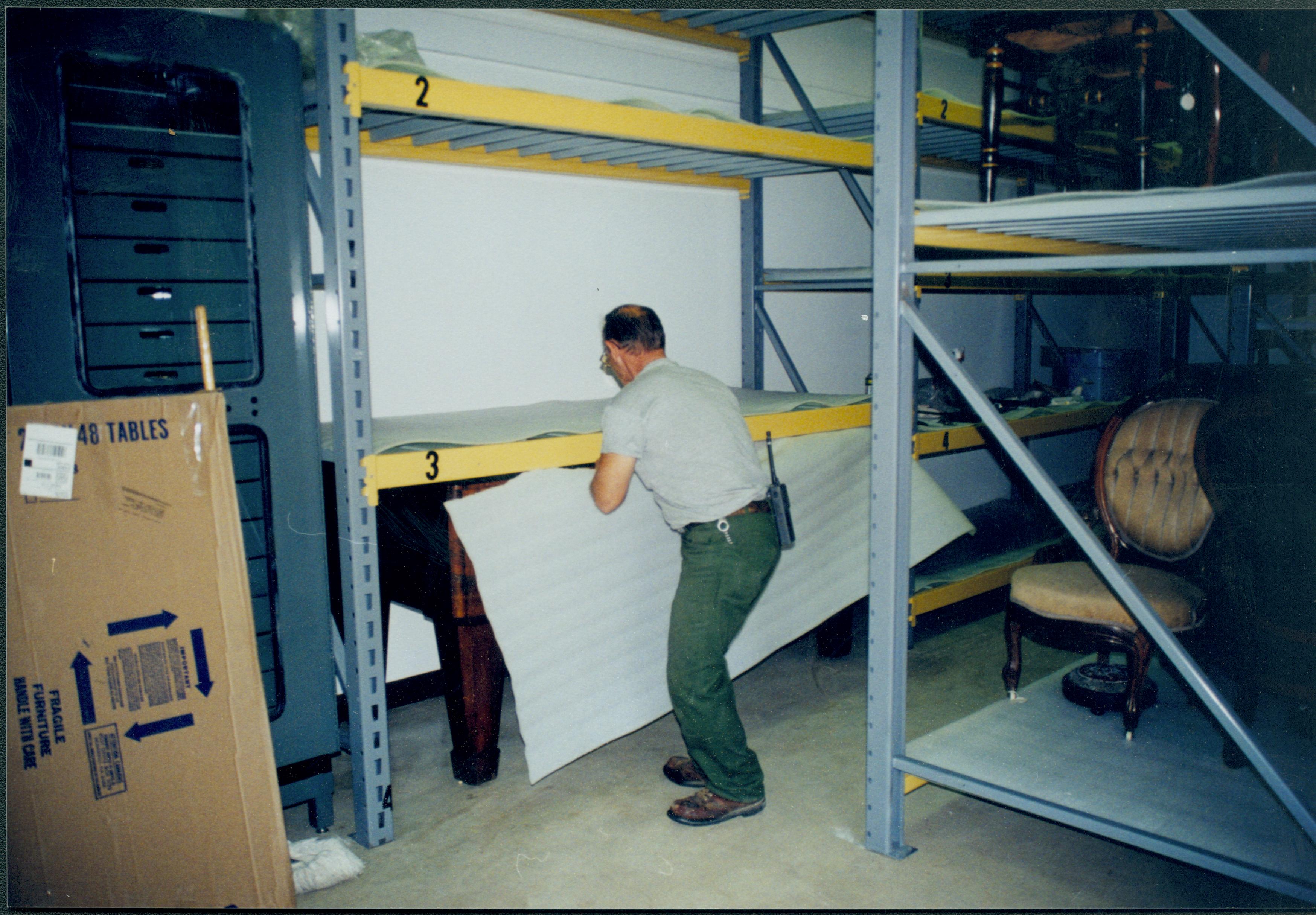 Members of maintenance mving piano into its new position in the Arnold Barn storage space. Photo taken from South aisle, looking at the North wall (A3 storage space) Lincoln Home NHS, 1998 CRS Collection Move, Roll N7, exp 17 sheet 6 of 9 Arnold Barn, storage room