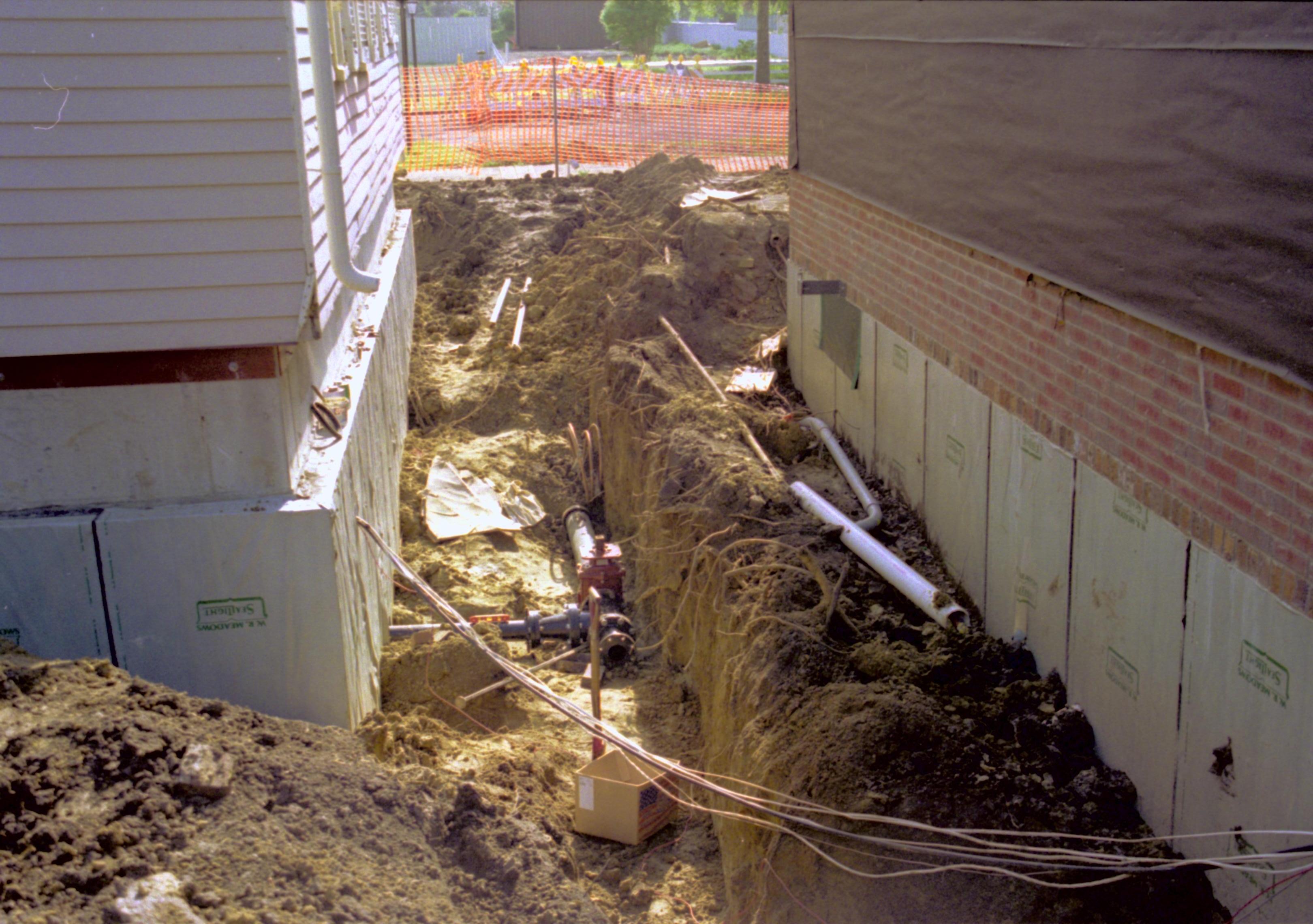 South line of Corneau, North ling of Sprigg properties; Various details being installed on Springg House. Northeast corner; photo taken looking west along North wall Lincoln Home NHS, Roll N6, Sheet 1 of 2 Arnold House and Property, exp 25 excavation, utilities, Sprigg, Corneau