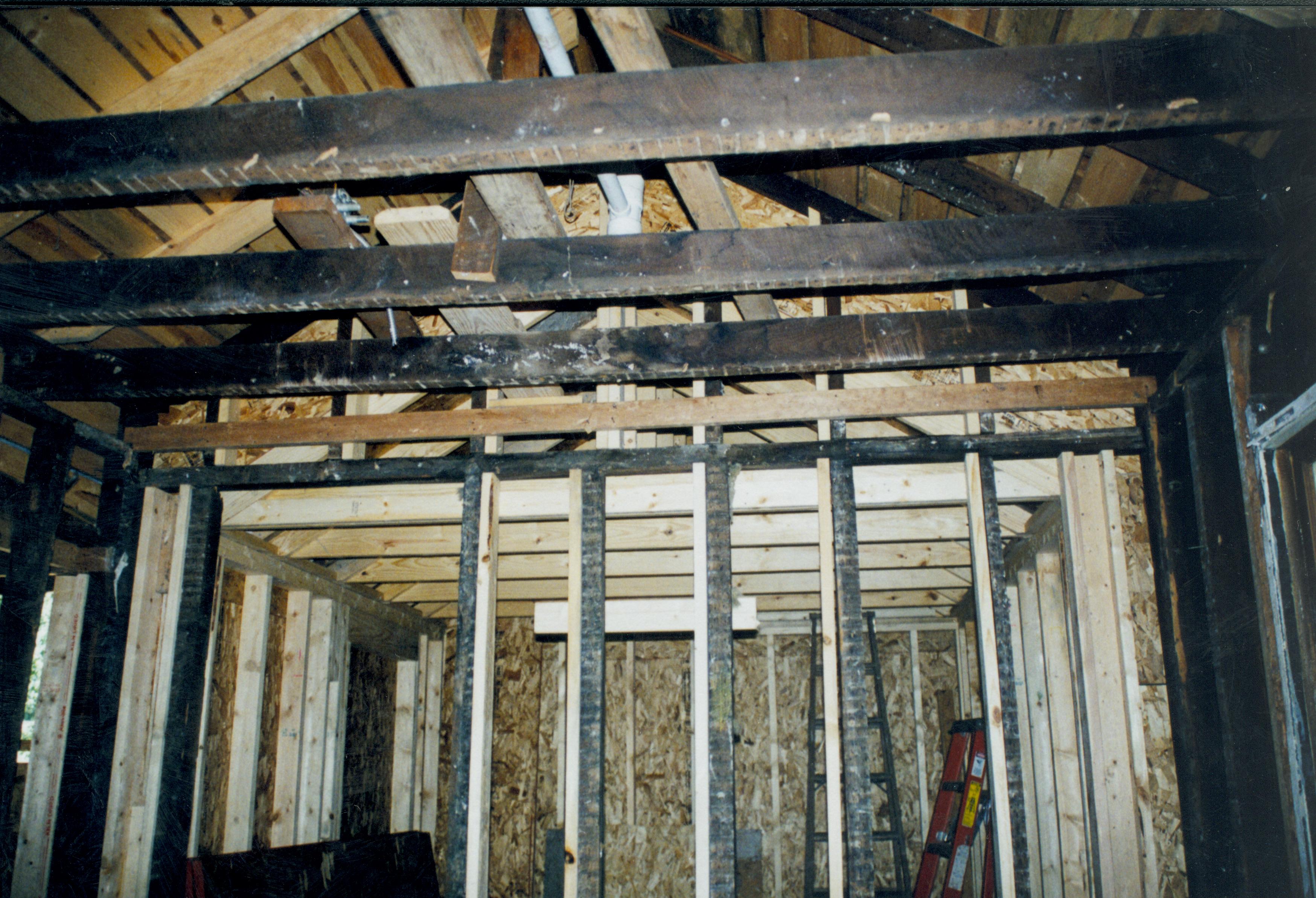 Blurry. Photo taken looking West, from room 104 into room 105 (addition). Detail of roof (joists, frames, rafters, etc.) and studs of wall between these two rooms. Northwest corner of room 104 visible at extreme right of photo Lincoln Home NHS- Corneau House Restoration, roll N9 exp 12 Corneau House, restoration