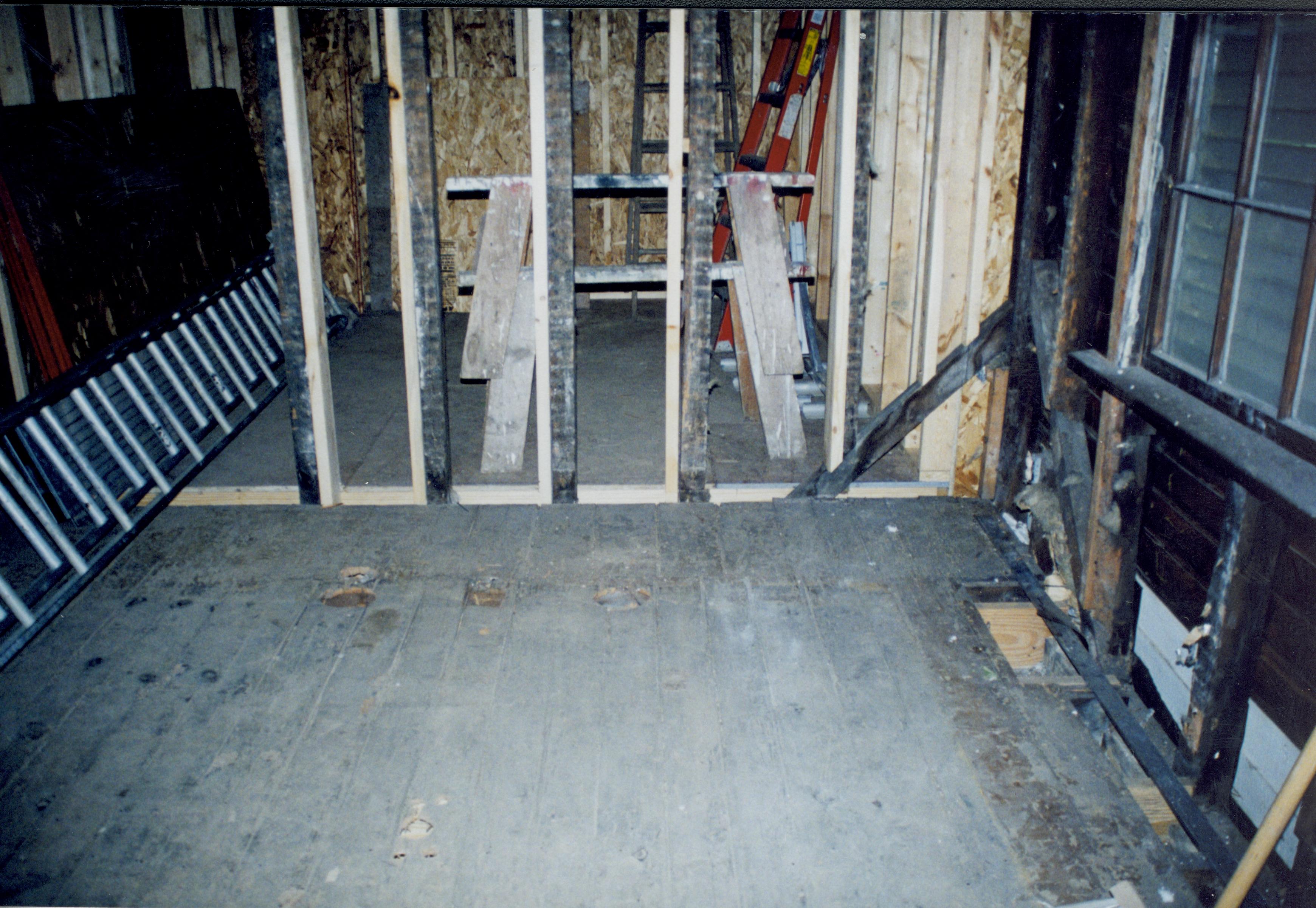 Blurry. Photo taken looking West, from room 104 into room 105 (addition). Detail of floor and studs, North wall visible at right side of photo Lincoln Home NHS- Corneau House Restoration, roll N9 exp 13 Corneau House, restoration