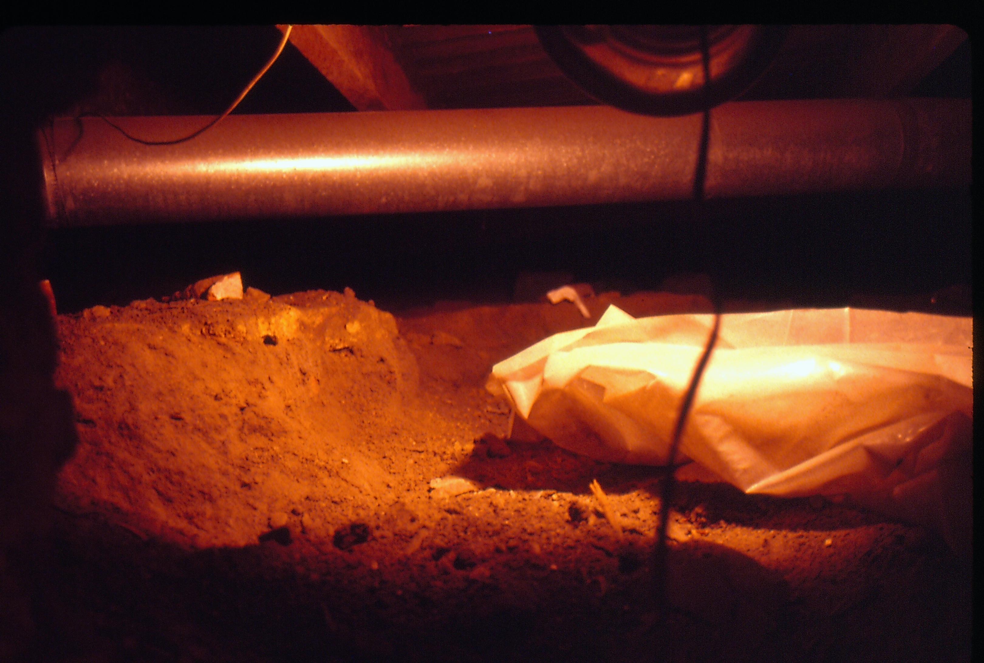 Lyon House - Crawlspace showing opening from rest of basement into crawlspace. Pipes visible near ceiling, wire for safety light hanging down, white plastic bag? within space filled with dirt and sand. Looking East from basement Lyon, Basement, crawlspace, pipes