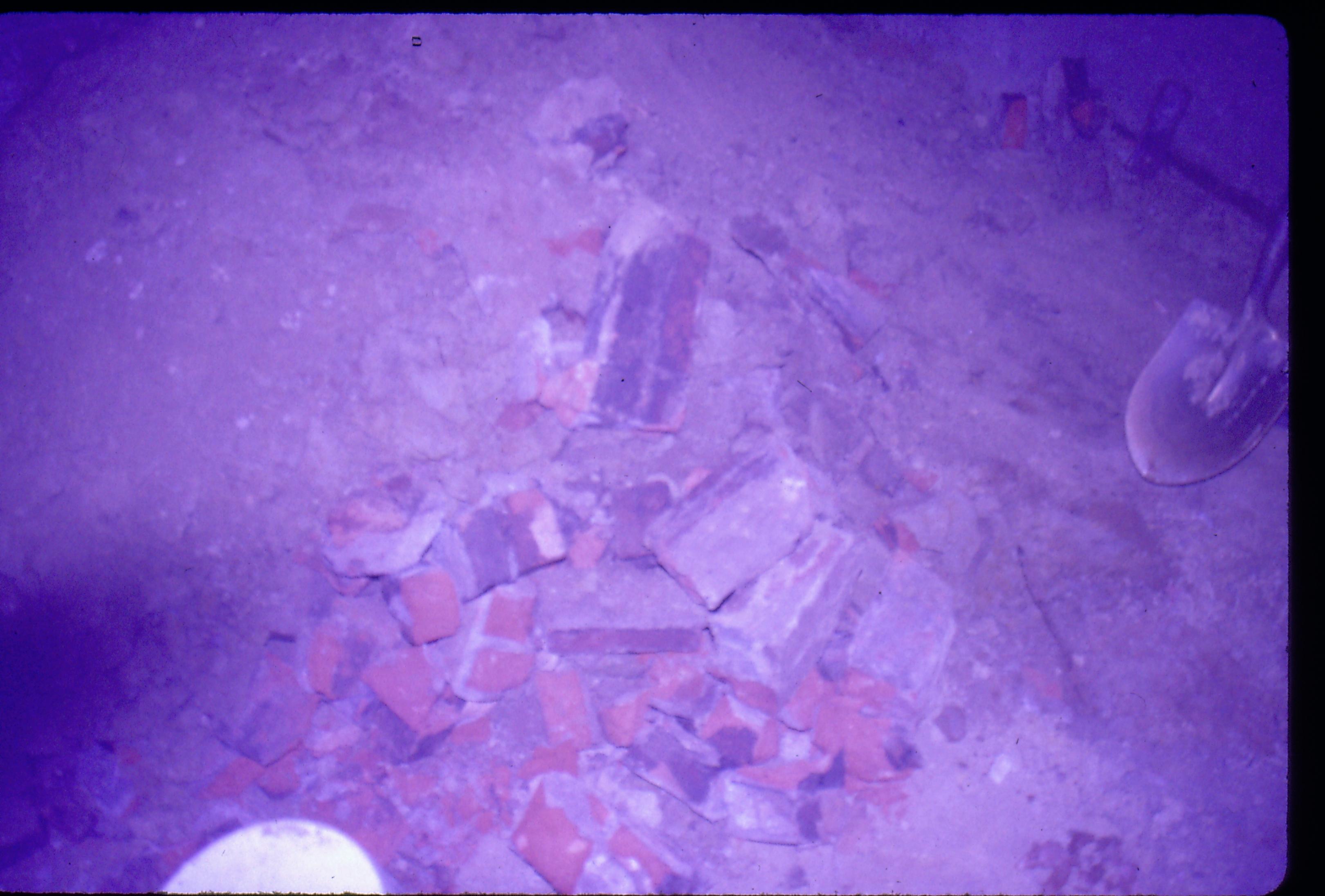 Lyon House - basement, pile of bricks removed from floor. Plastic drain cover in foreground left. Shovel leaning against wall on right. Looking East from basement Lyon, Basement, brick