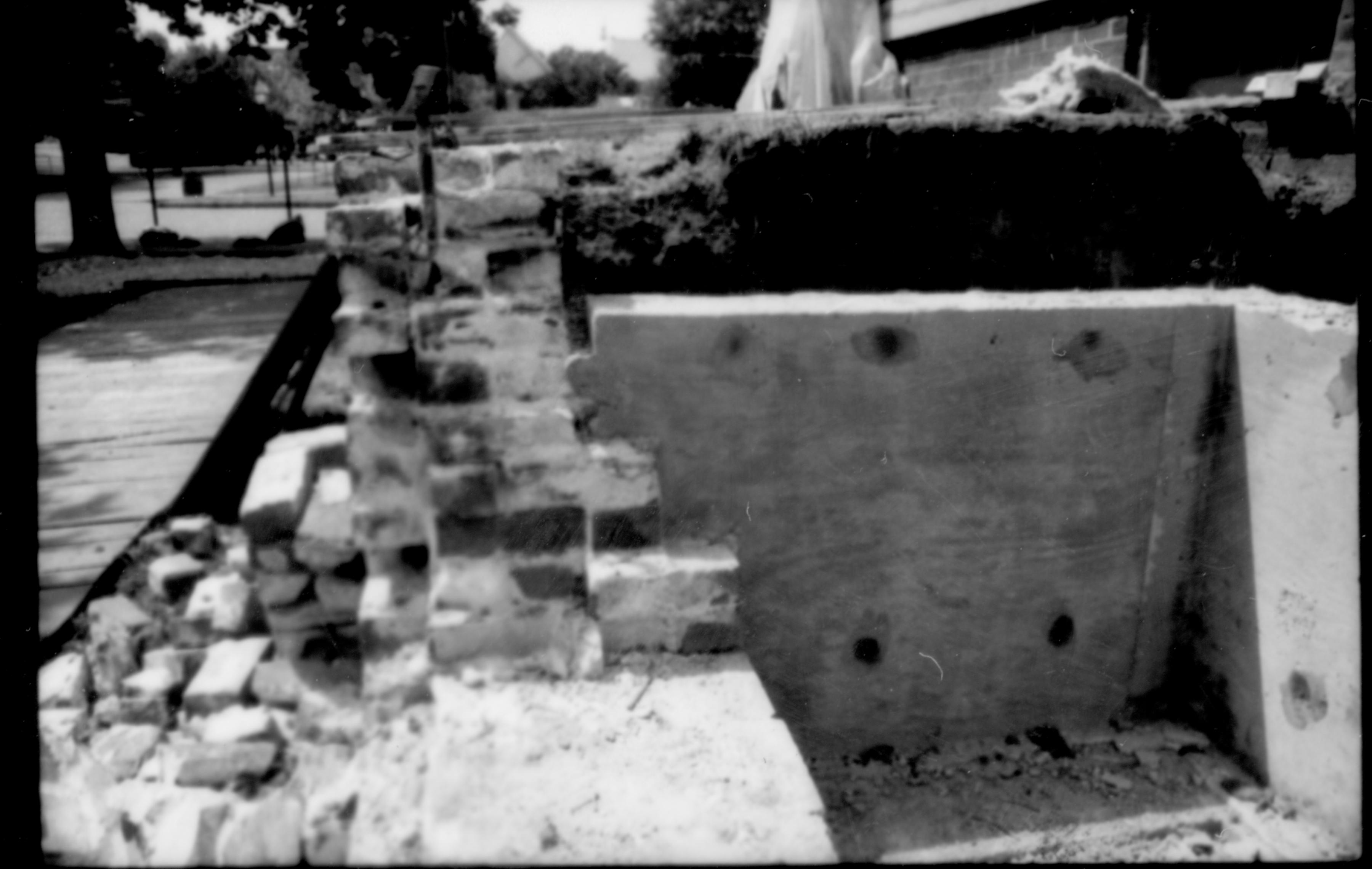 South retaining wall, and plywood form for concrete stair support, near south porch of Lincoln Home and lot. Photographer facing west.