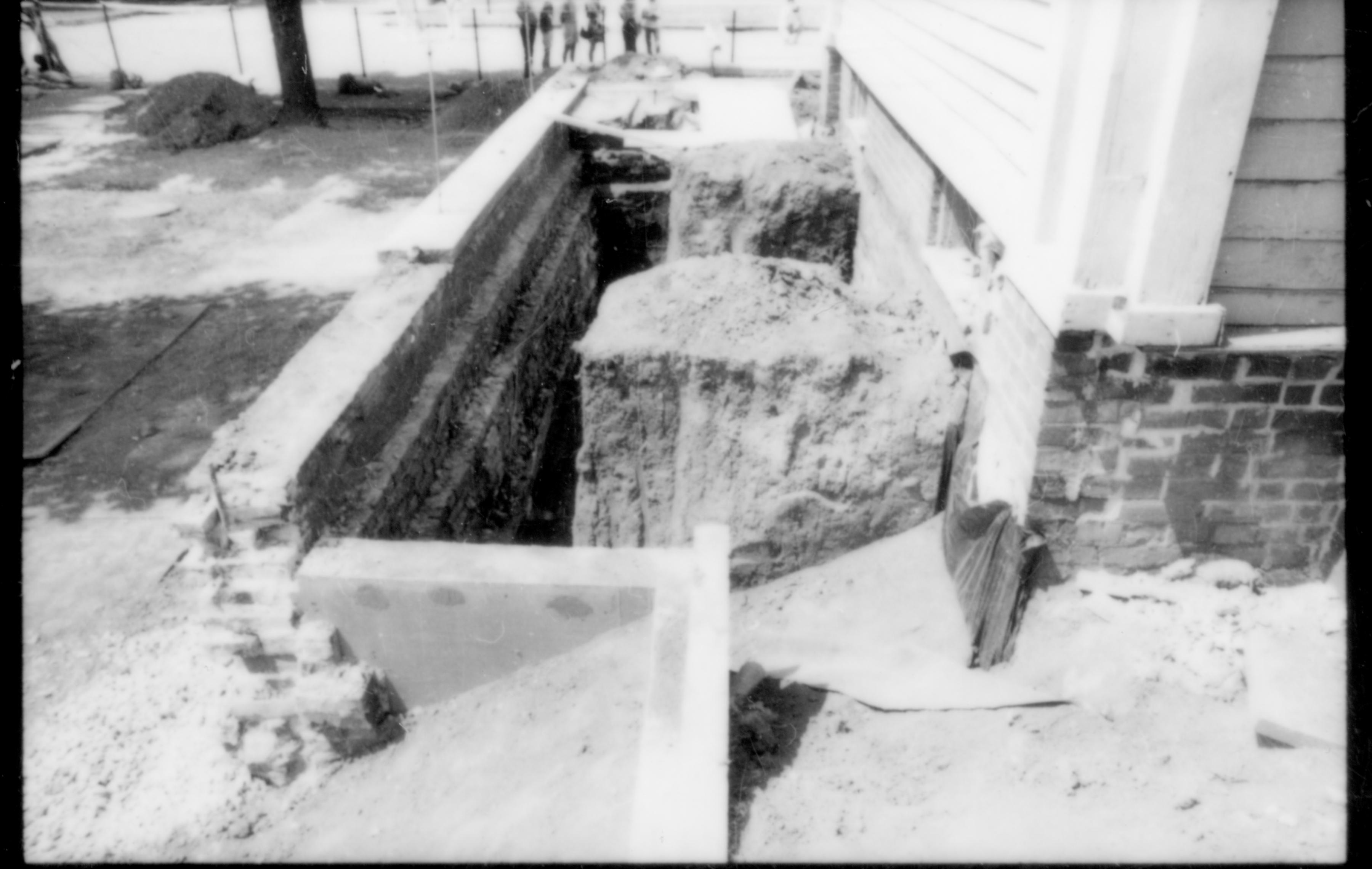 The wall foundation, yard, and retaining wall along the south side of the Lincoln Home during the 1987-88 restoration. At this point in the construction, the south porch had been removed (seen on the far right of the photo), as well as the fencing along the south and west sides of the lot. Photographer facing west.