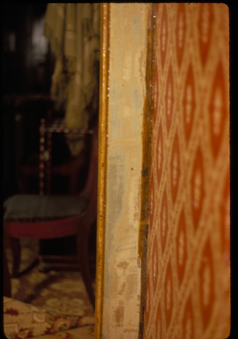 Detain of the door frame between the Dining Room and 1st floor Front Hall, with original chair and hat rack in left background. Photographer facing west from Dinign Room into hall.