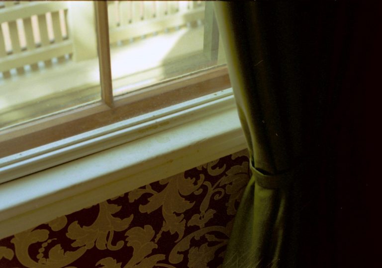 Photo of window 108 W-1 in the Sitting Room, showing damage and staining due to a leak in the window frame. Note staining at bottom of storm window frame and window sill. Photographer facing west.