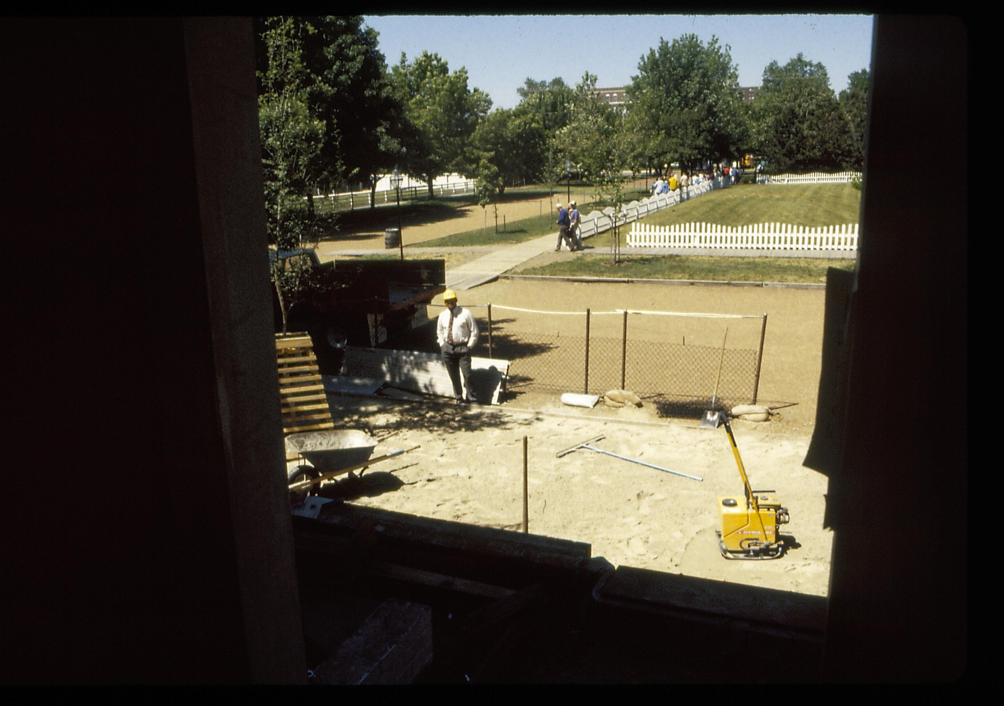 Laing the sand substrate of the Lincoln Home brick plaza. West entrance/door frame of Lincoln Home in foreground. Burch lot in background. Photographer facing west.