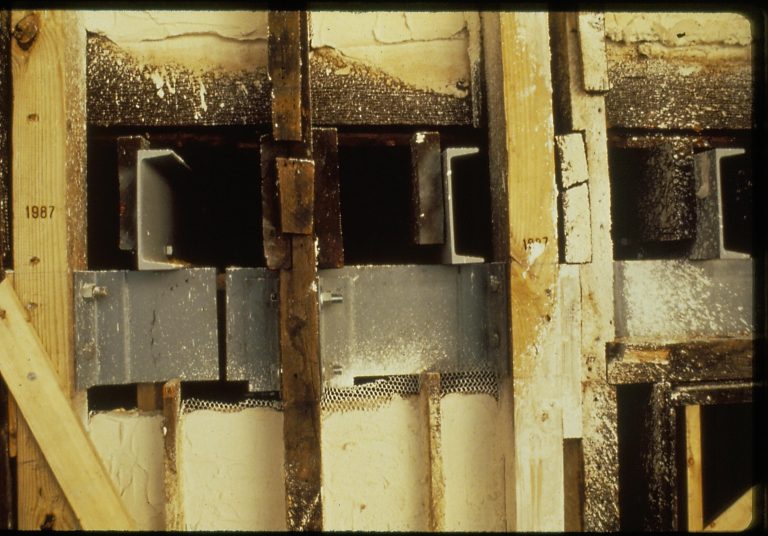 Side view of steel beams as attached to floor joists and ceiling above the Back Parlor. Original beams are mixed in alongside the new beams.
