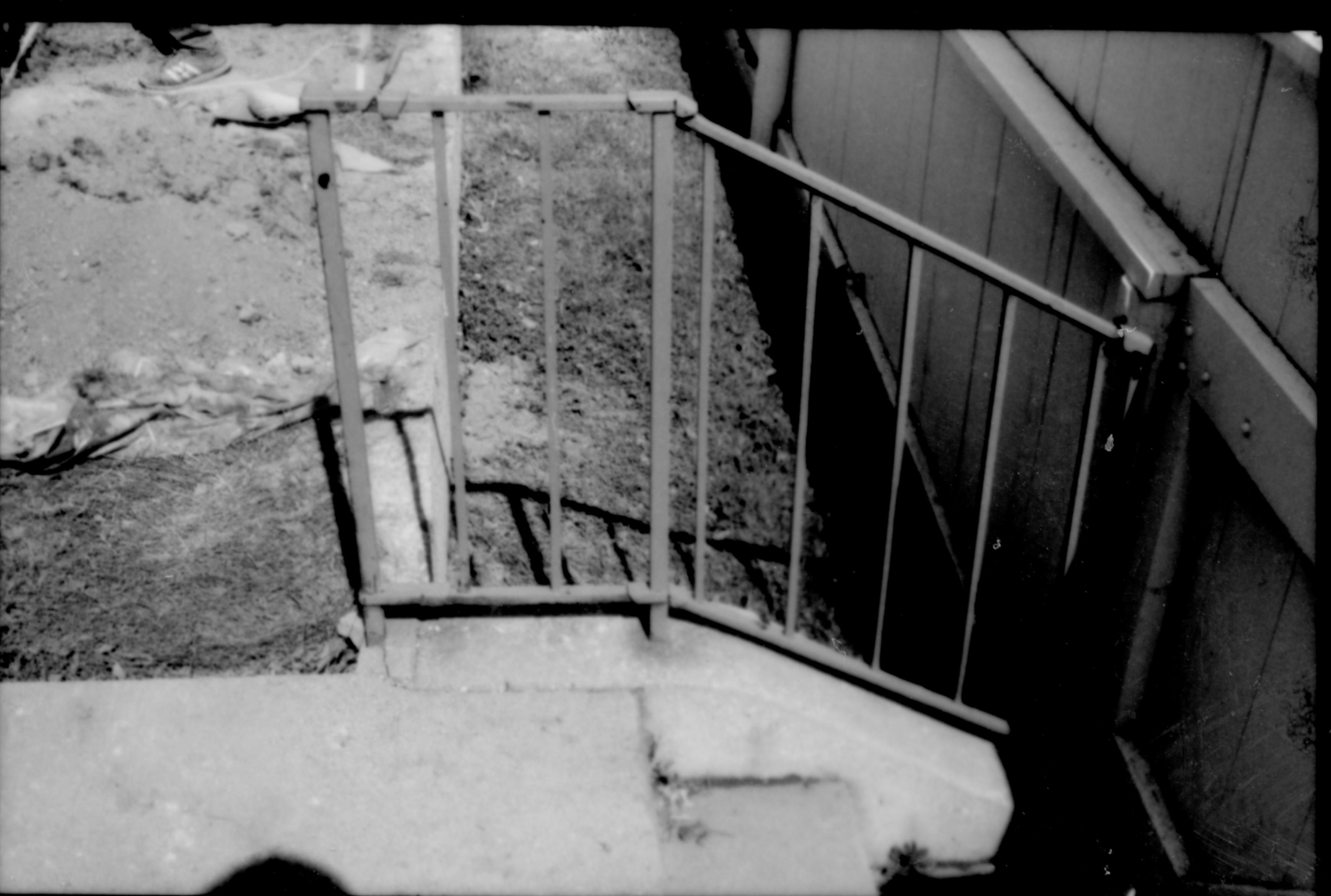 View of the south porch exit, steps, and metal handrail prior to the 1987-88 restoration. Photographer facing east.