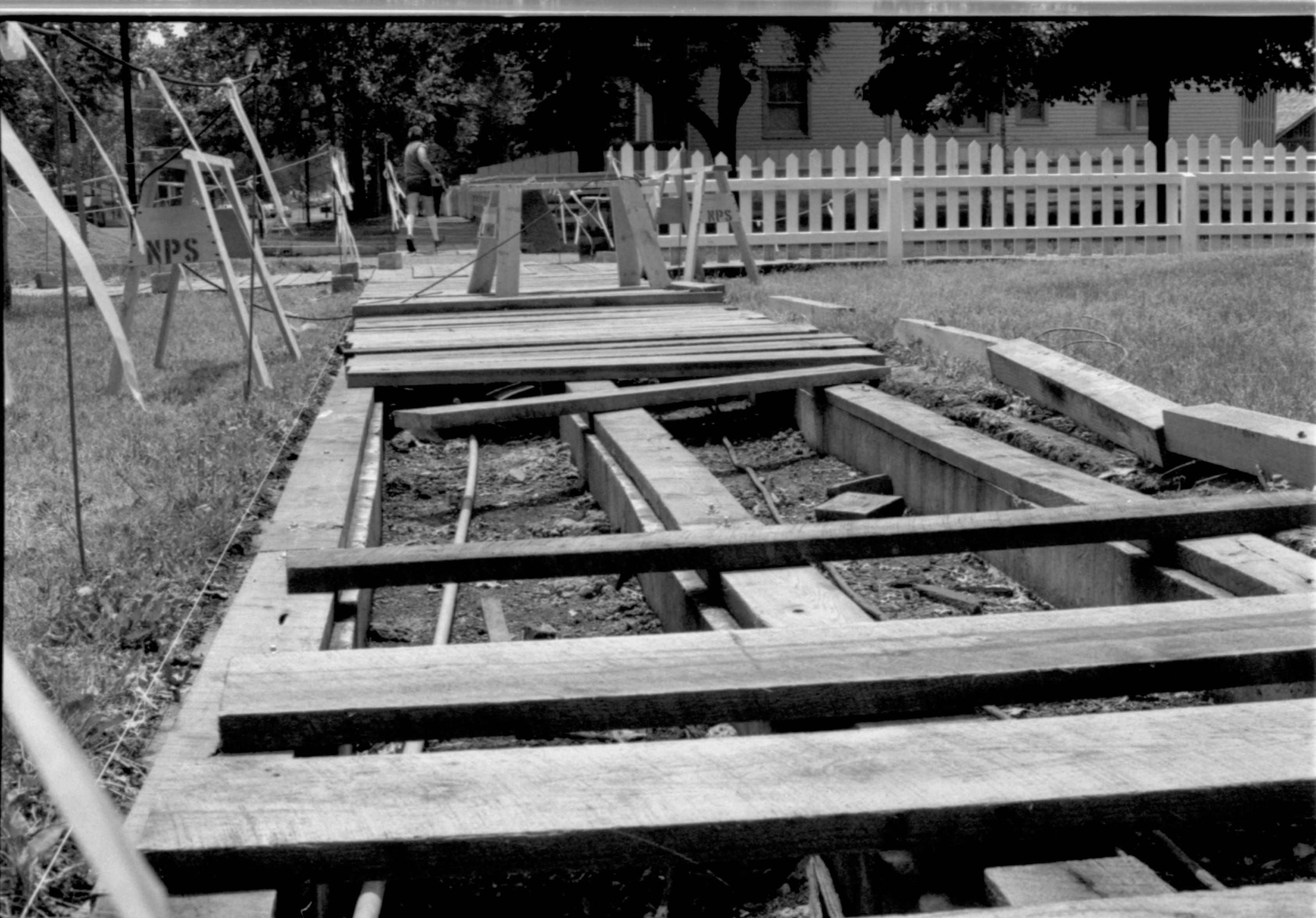 A section of boardwalk, along Eighth Street north of Jackson, being replaced. The Sprigg house, pre-restoration, appears in the background. Photographer facing south.